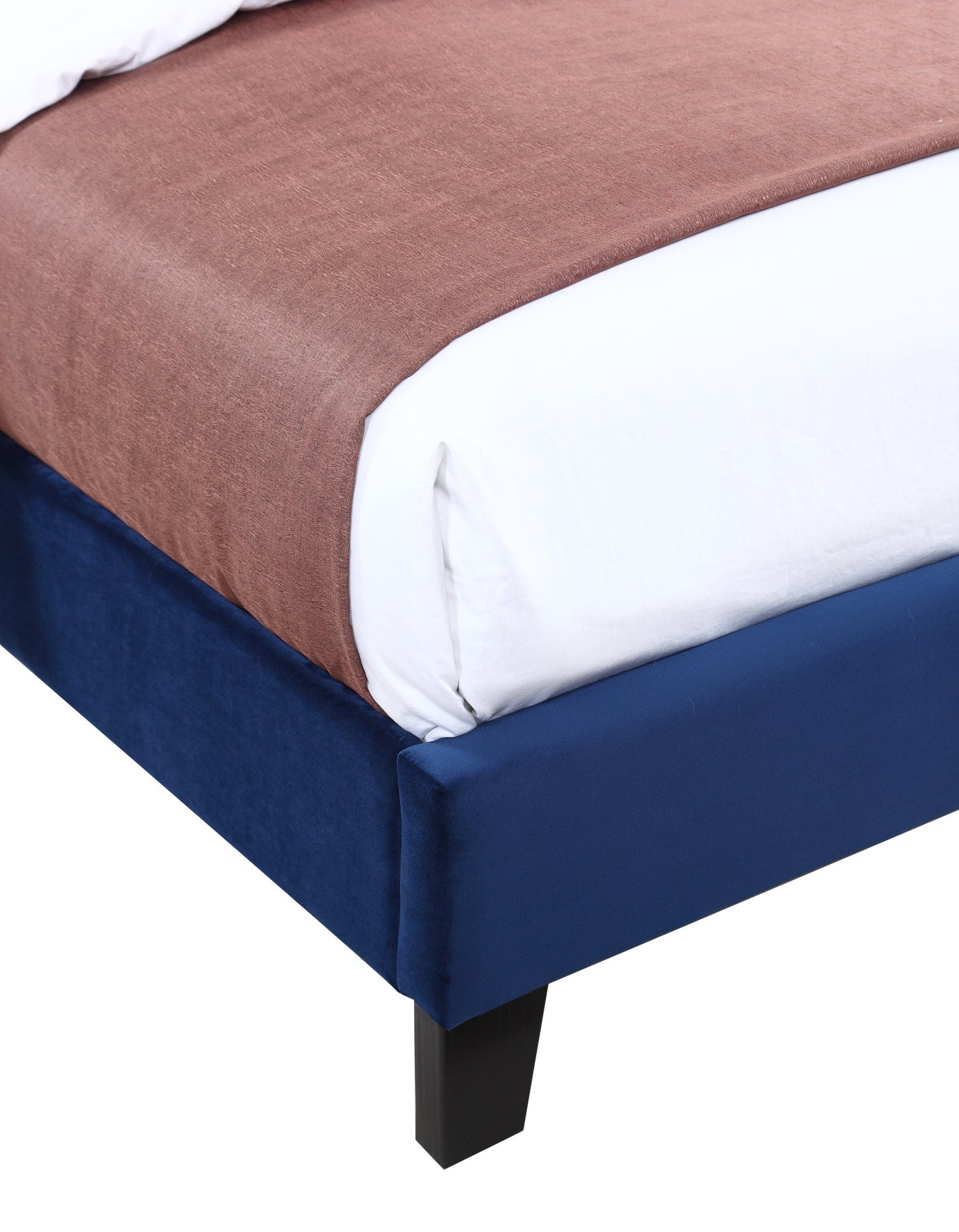 Navy velvet platform bed frame with brown throw and white bedding