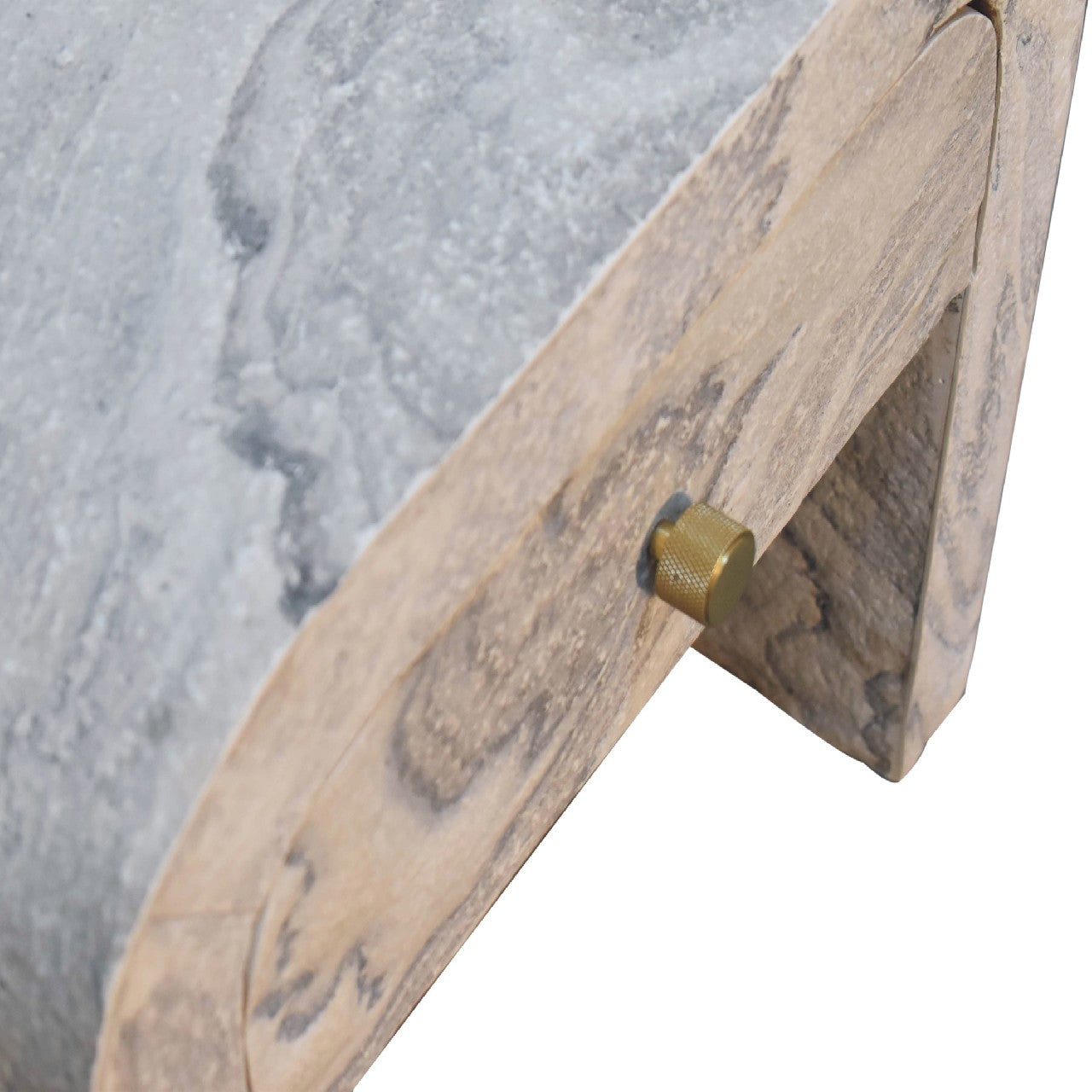 Close up of a wooden drawer handle with brass knob on a textured surface