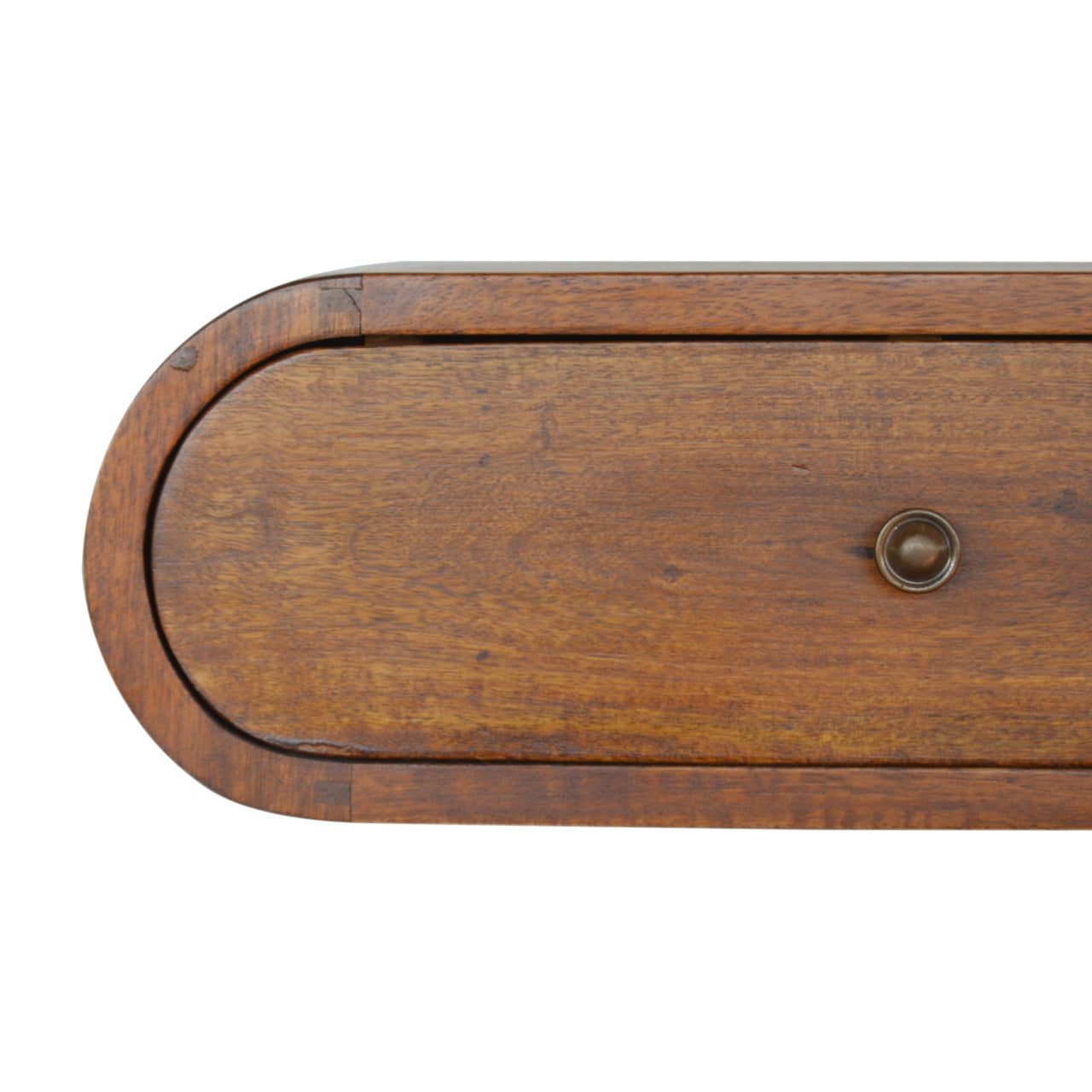 Closeup of a wooden dresser drawer with a rounded front and antique brass knob