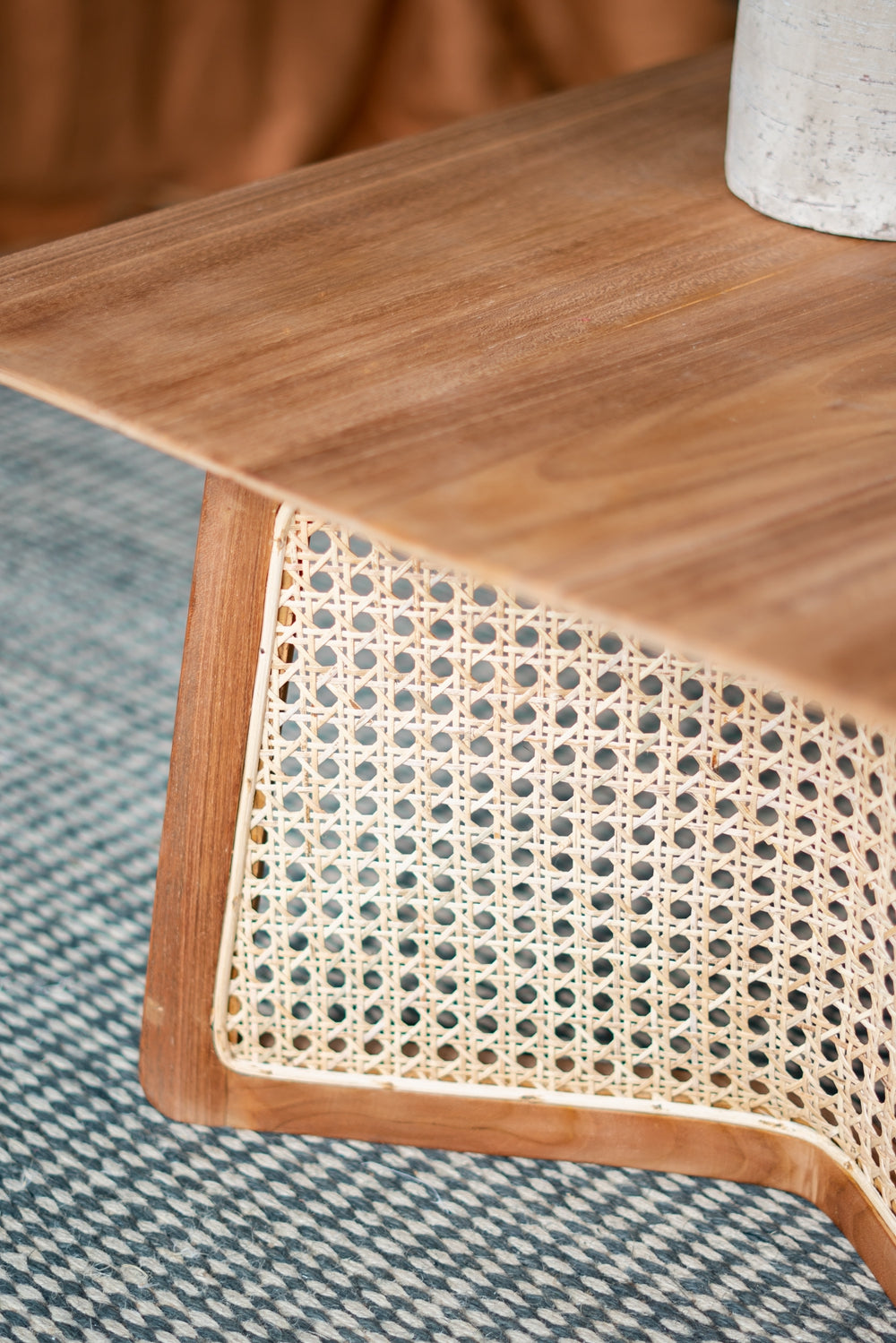 Natural wood coffee table with woven cane detail and clean lines