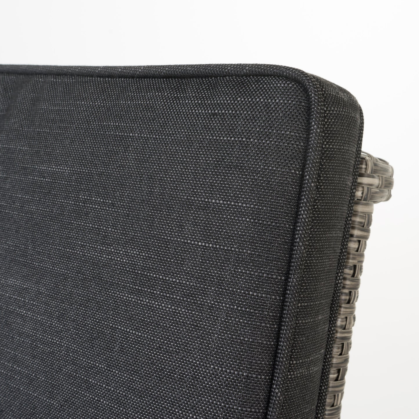 Closeup of a dark grey outdoor cushion with woven wicker side detail