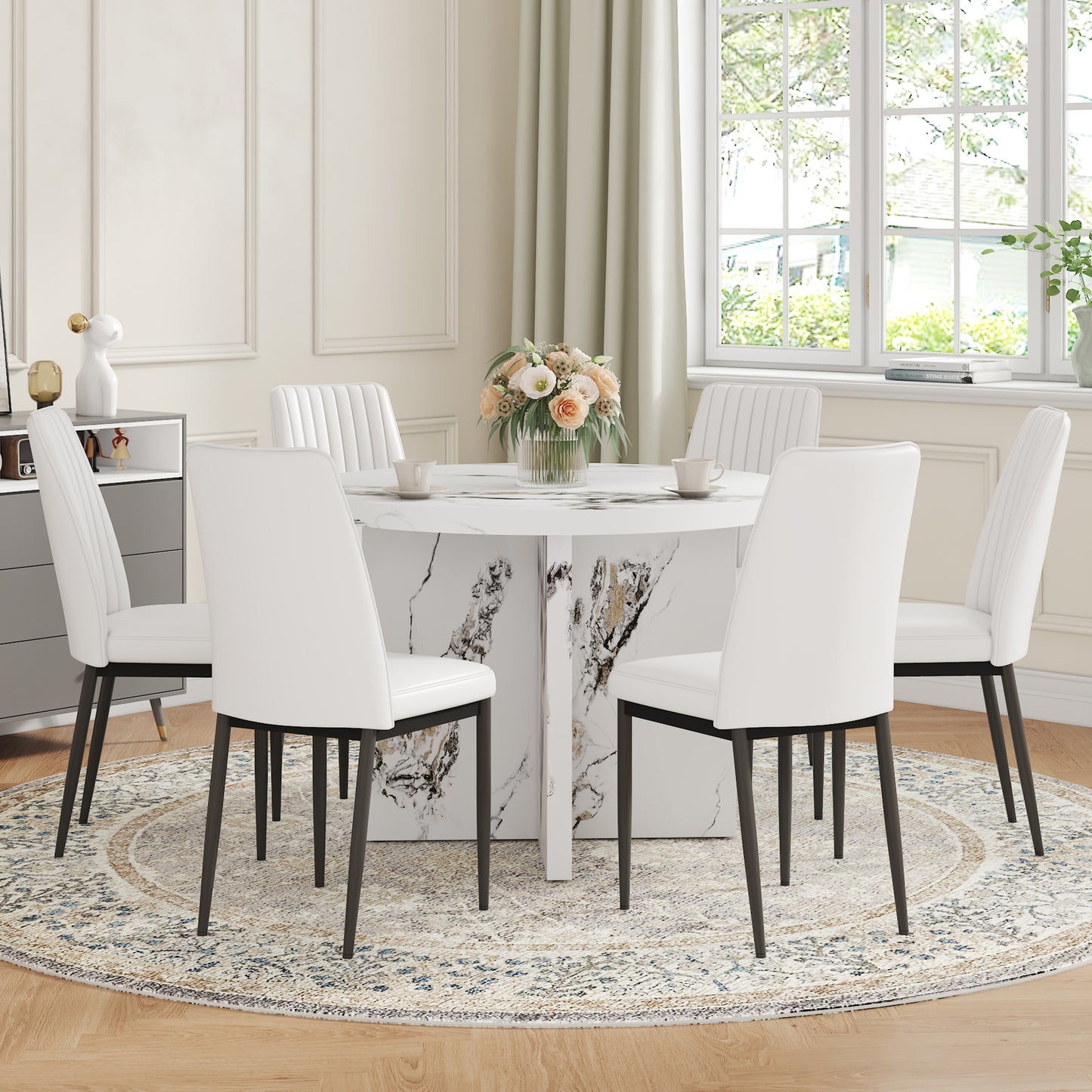 White leather dining chairs with fluted backs around a marble pedestal dining table