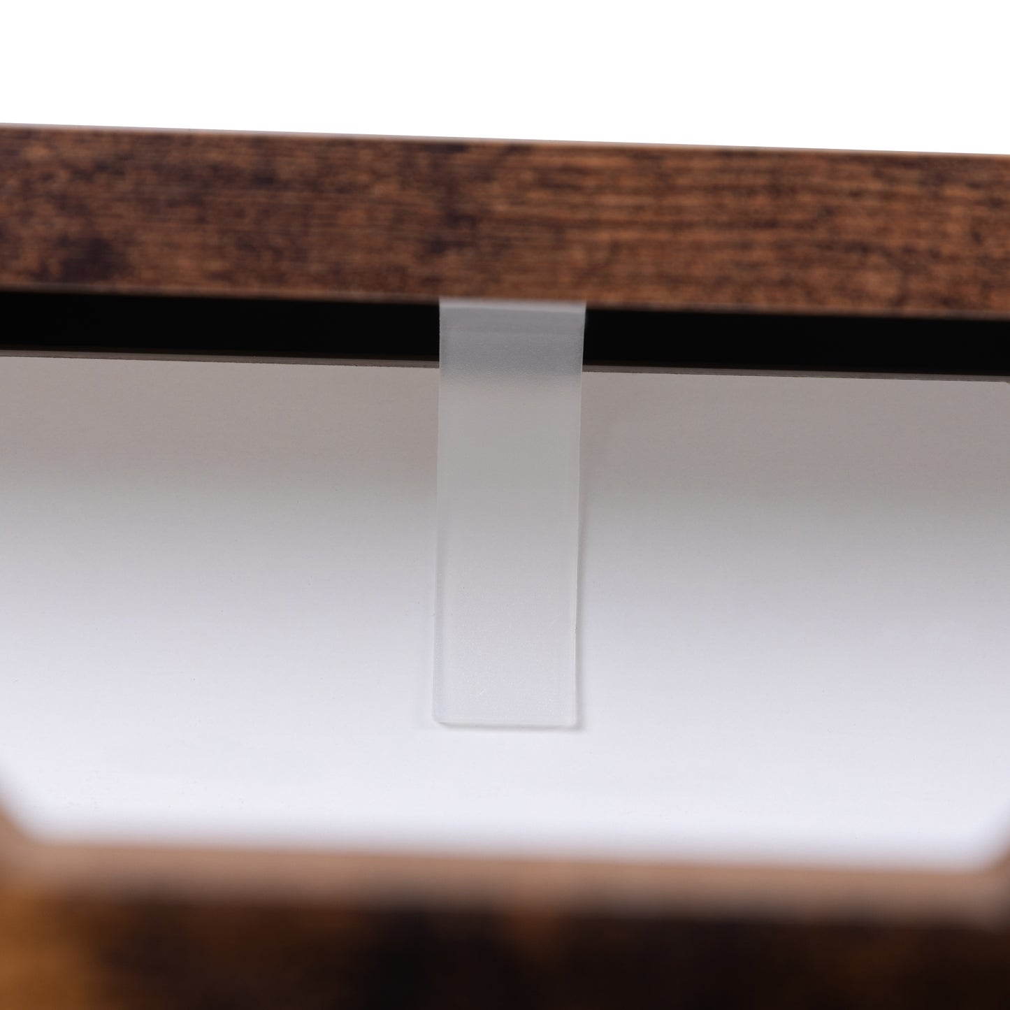 Rustic brown wood desk edge with clear plastic modesty panel connector
