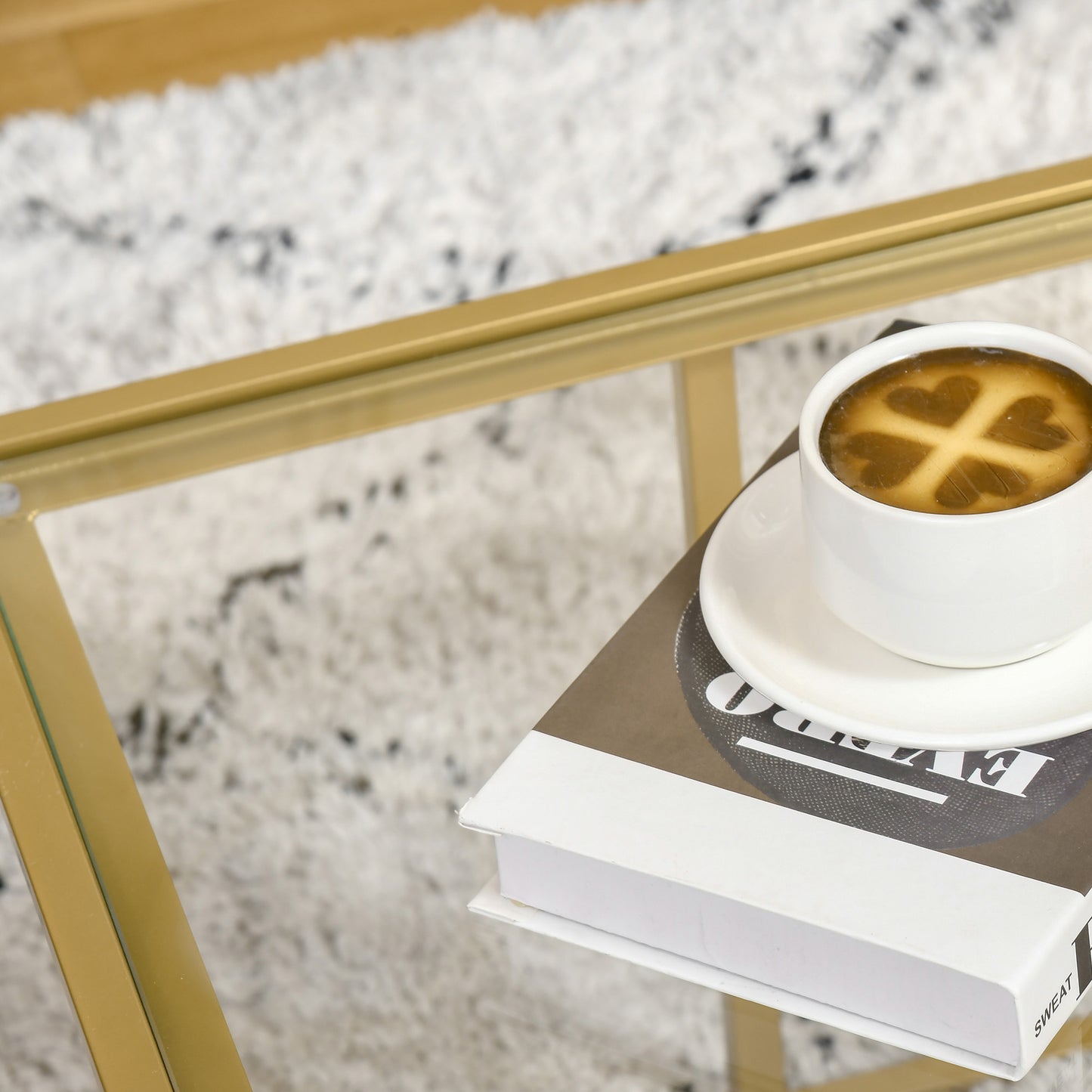 White ceramic coffee cup with clover latte art on a saucer placed on a book