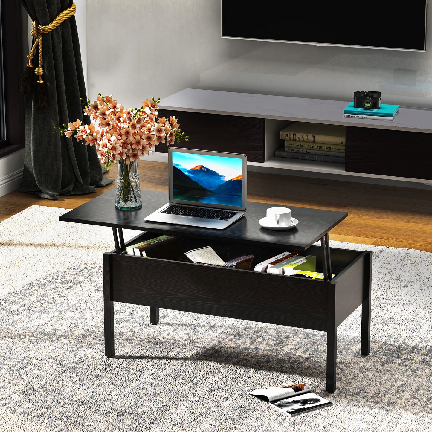 Dark wood lifttop coffee table with open storage holding a laptop and books