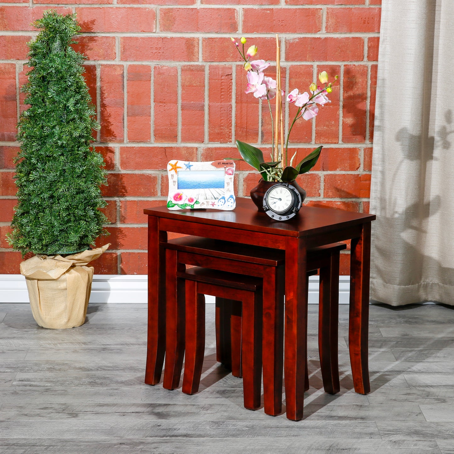 Cherry wood nesting tables set of three with a decorative frame and plant