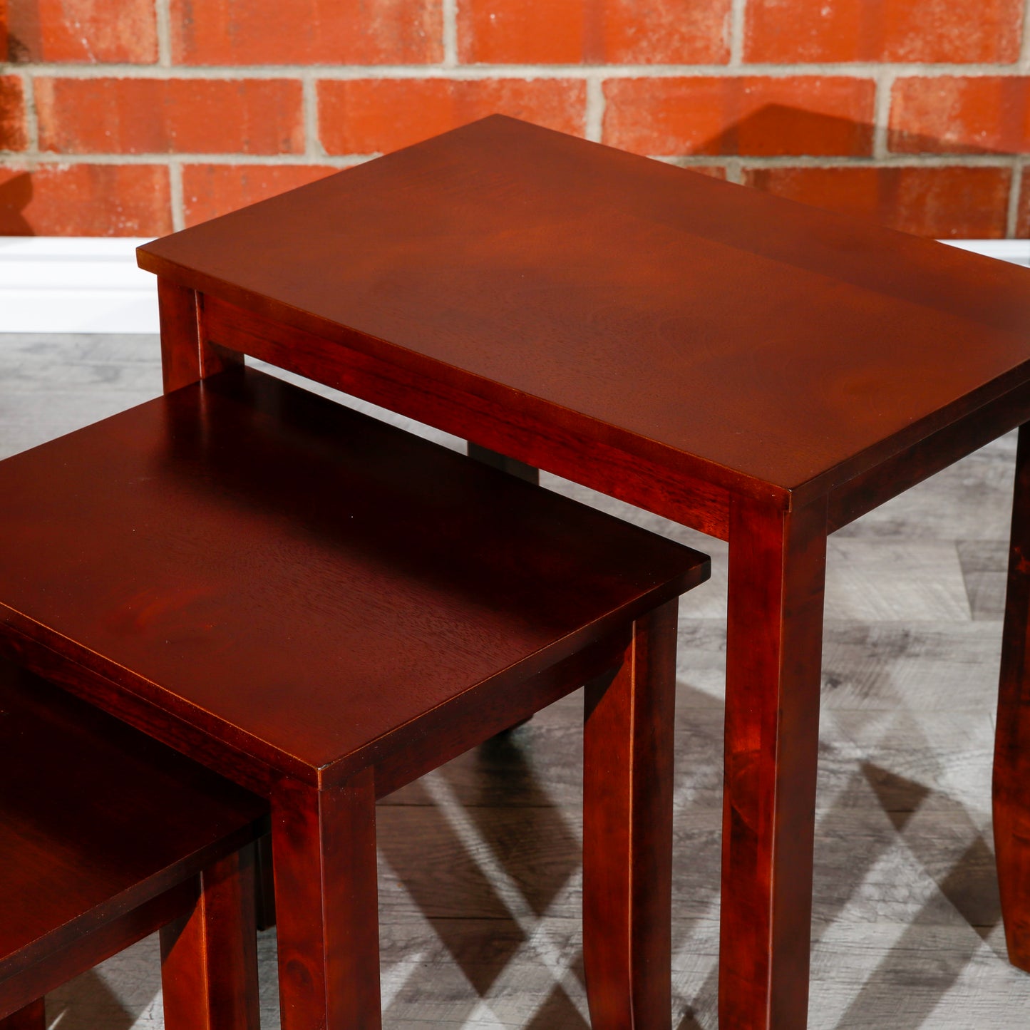 Three wooden nesting tables in a rich cherry finish perfect for compact living spaces