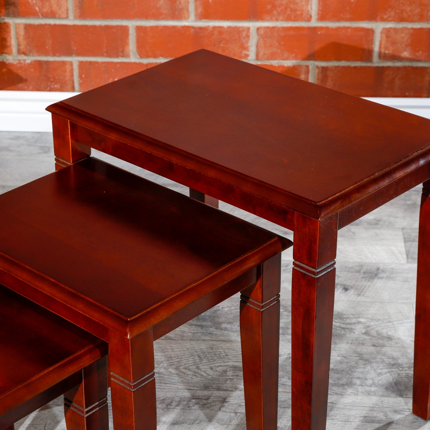 Rich mahogany nesting tables with tiered detailing perfect for living room use