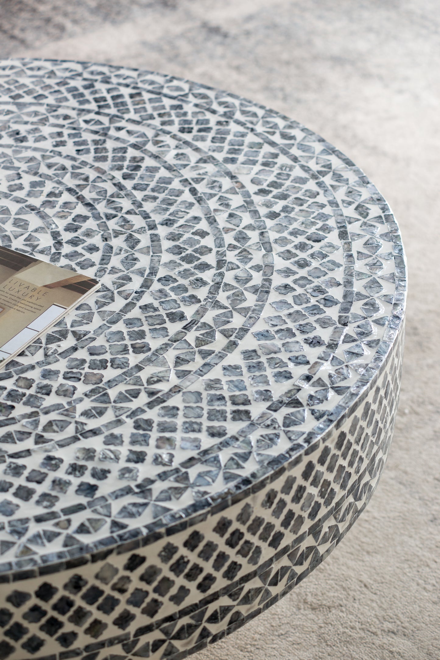 Round inlay coffee table with geometric mosaic pattern in black and white