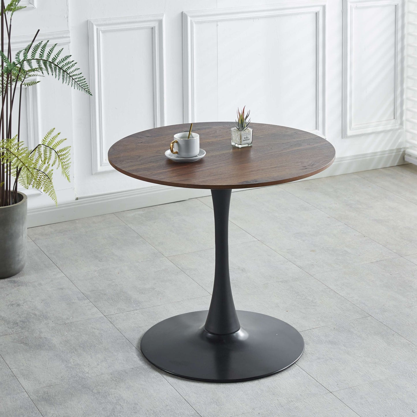 Round dark wood dining table with a black tulip base for intimate gatherings