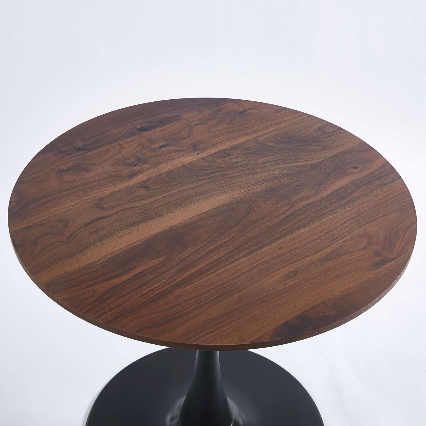 Round walnut wood dining table with black pedestal base