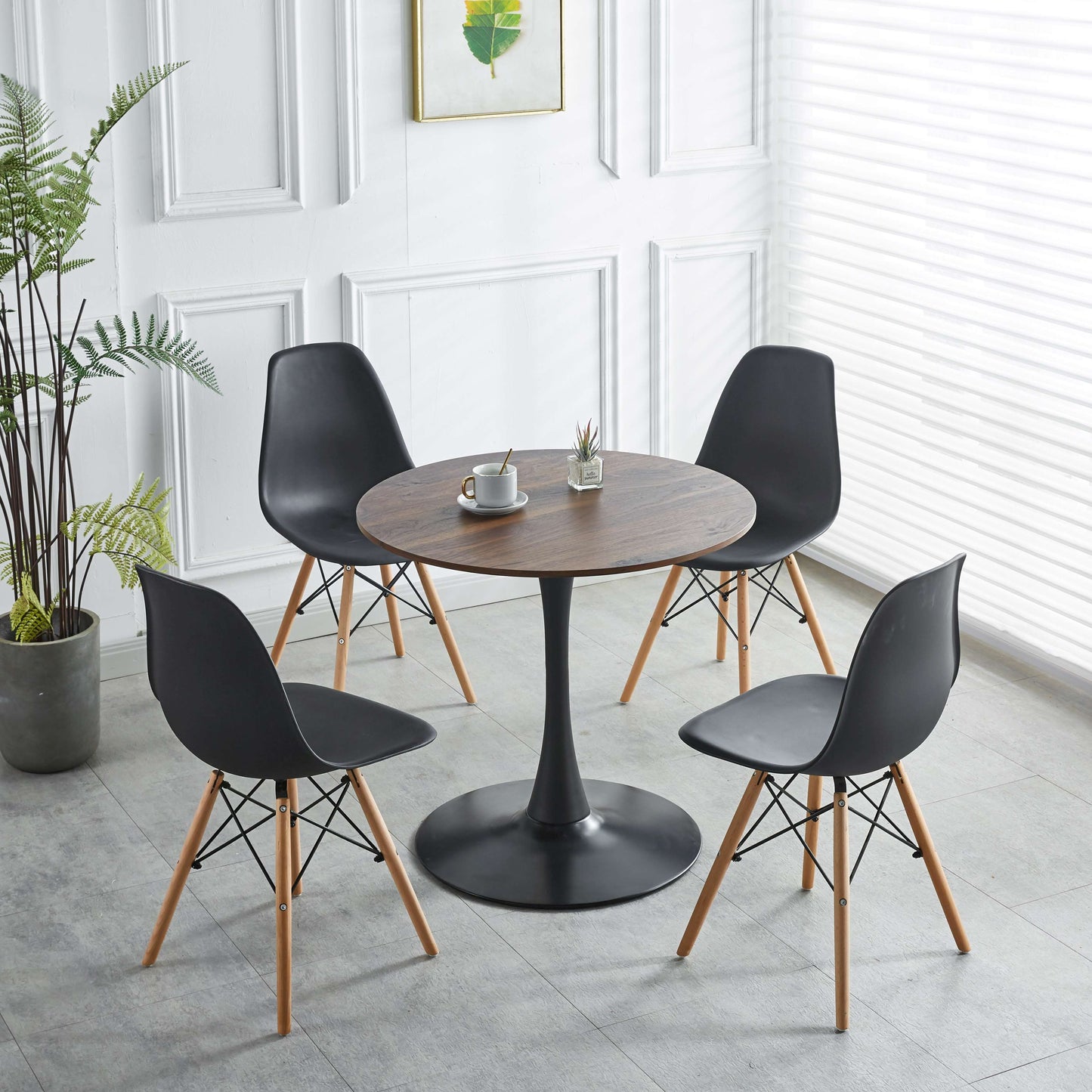 Round wood dining table with black tulip base paired with four black modern chairs