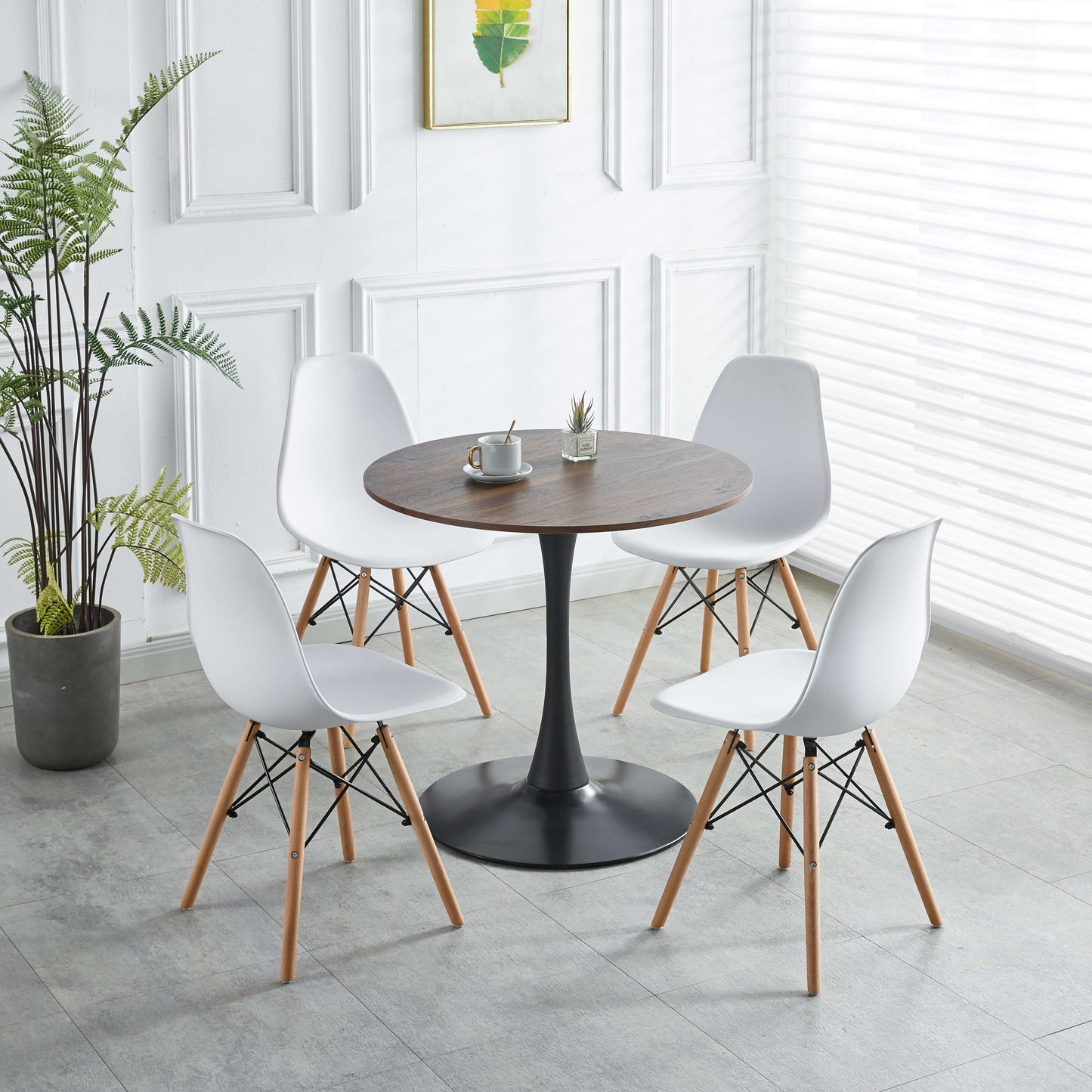 Four white dining chairs with wooden legs around a round walnut table for modern dining