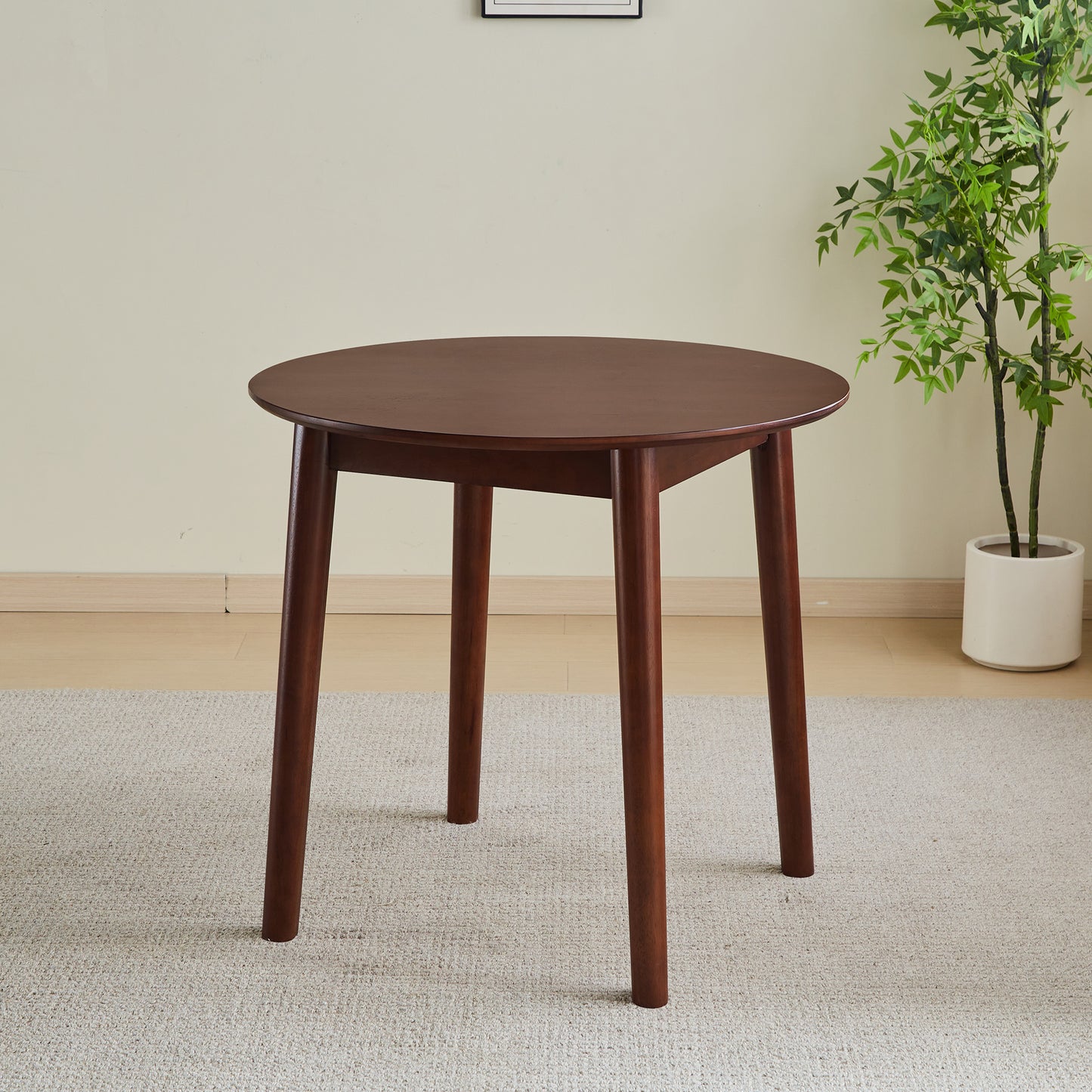 Round walnut dining table with tapered legs