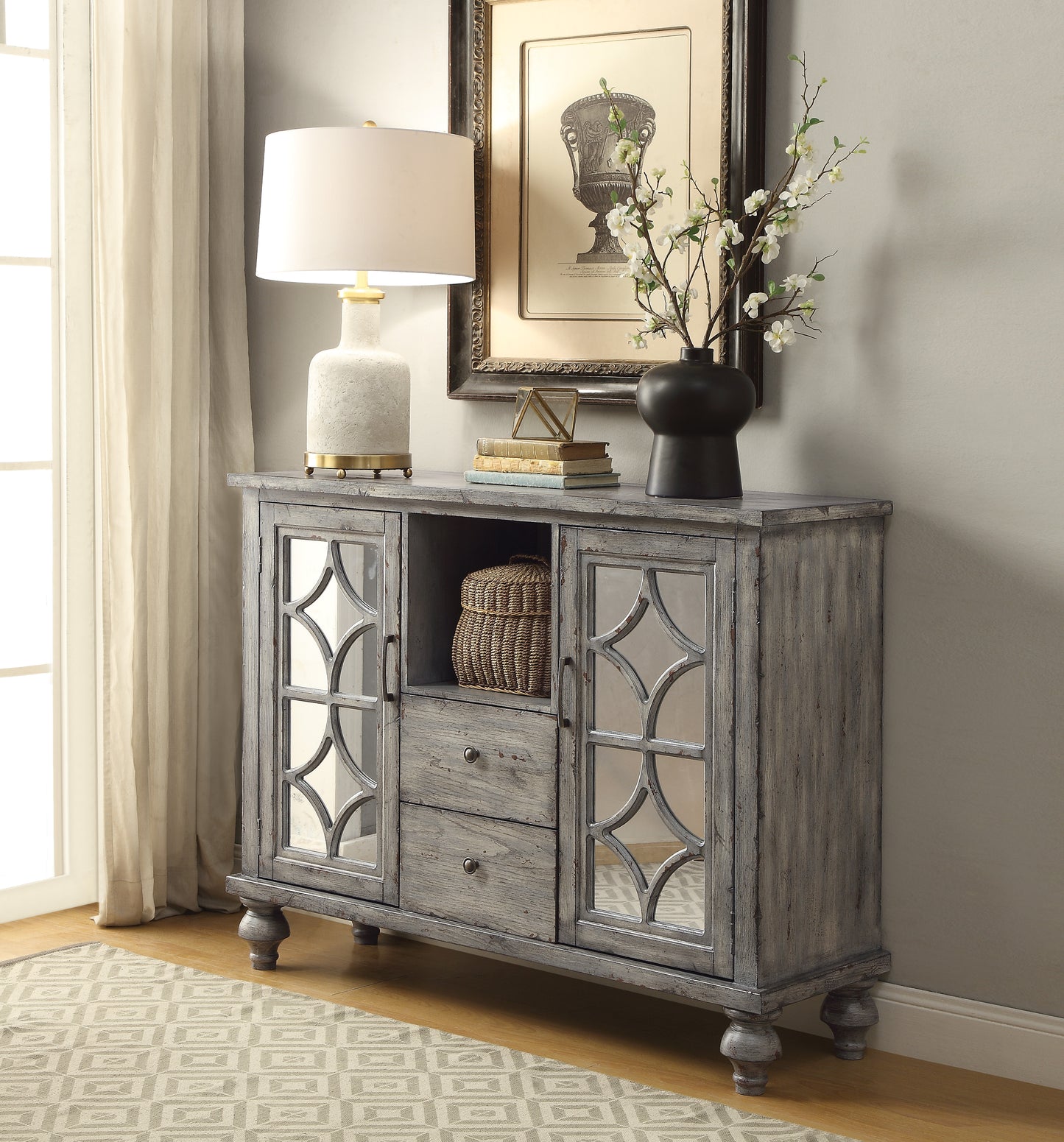 Distressed gray console table with mirrored doors and decorative accents