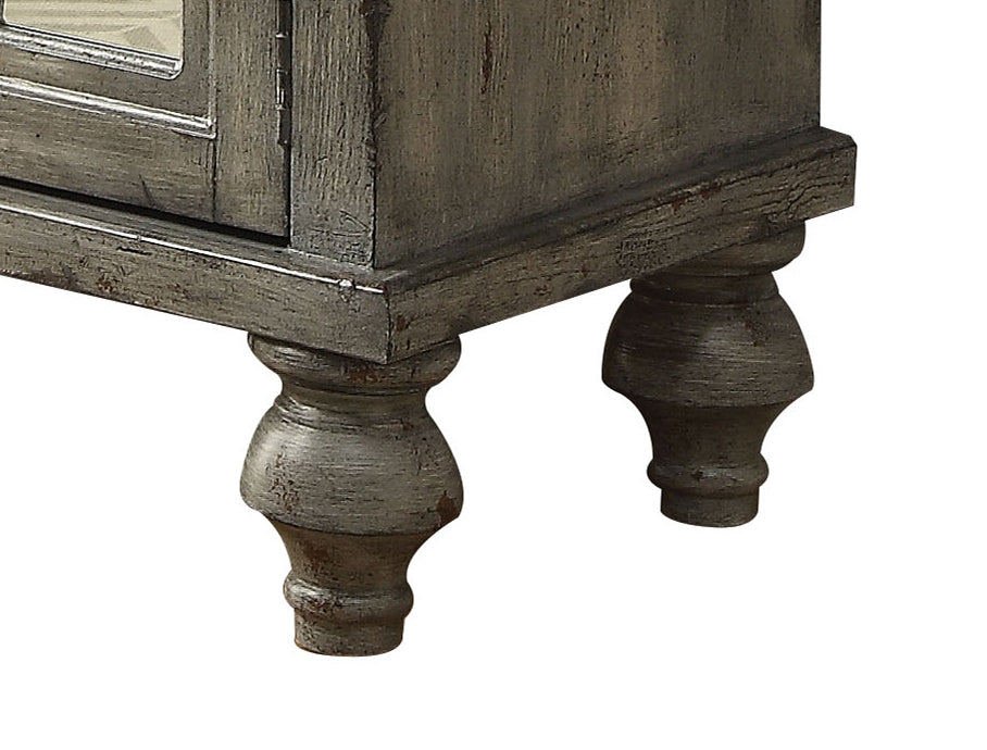 Distressed gray wooden cabinet legs with turned detailing