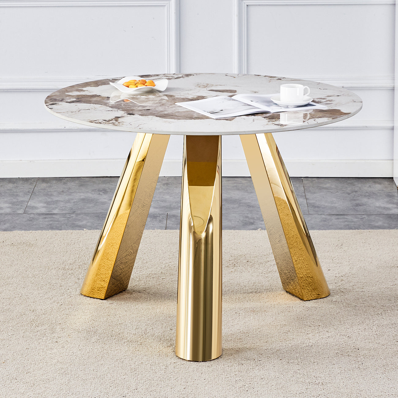Round marble top dining table with polished gold pedestal legs