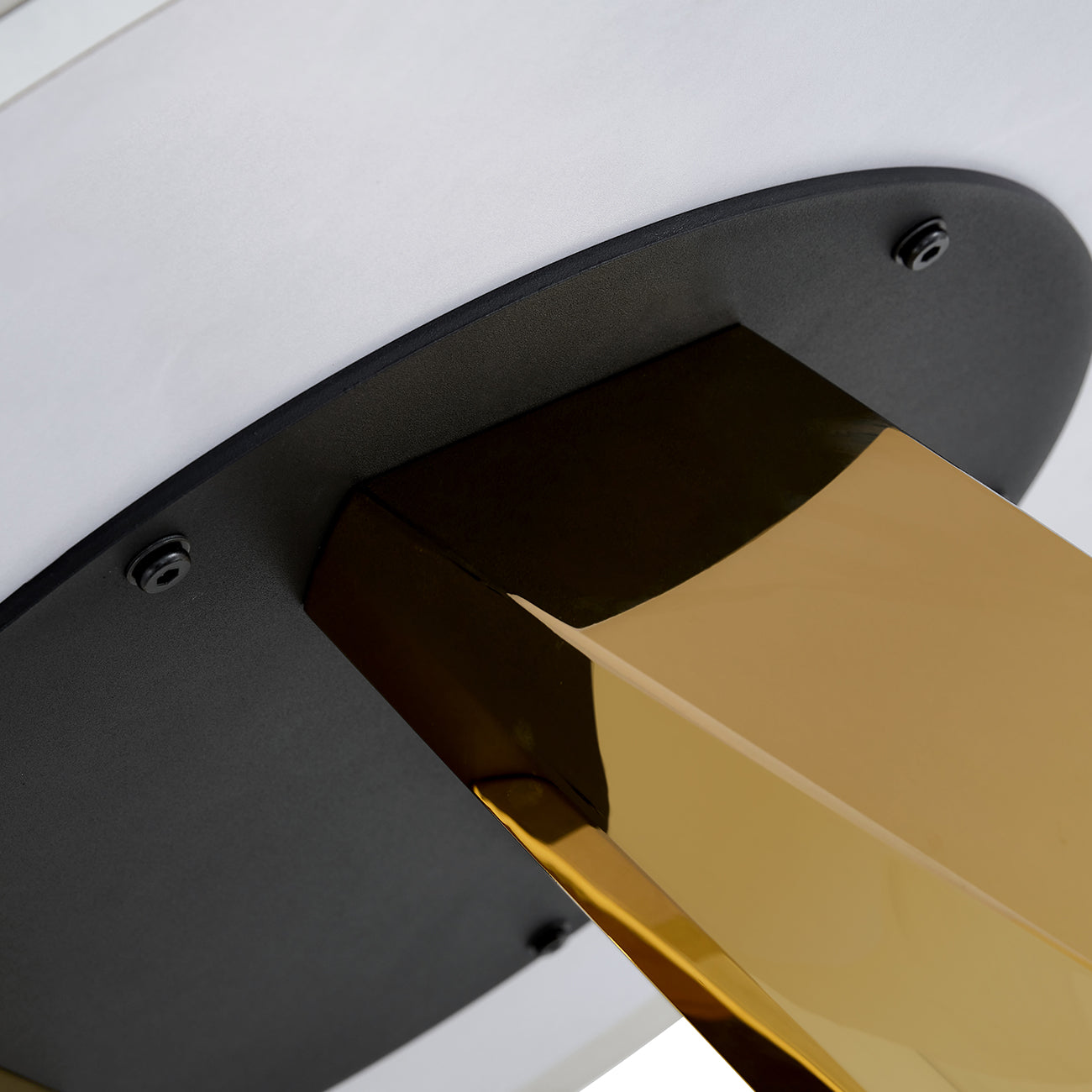 Polished brass table leg detail with black mounting plate