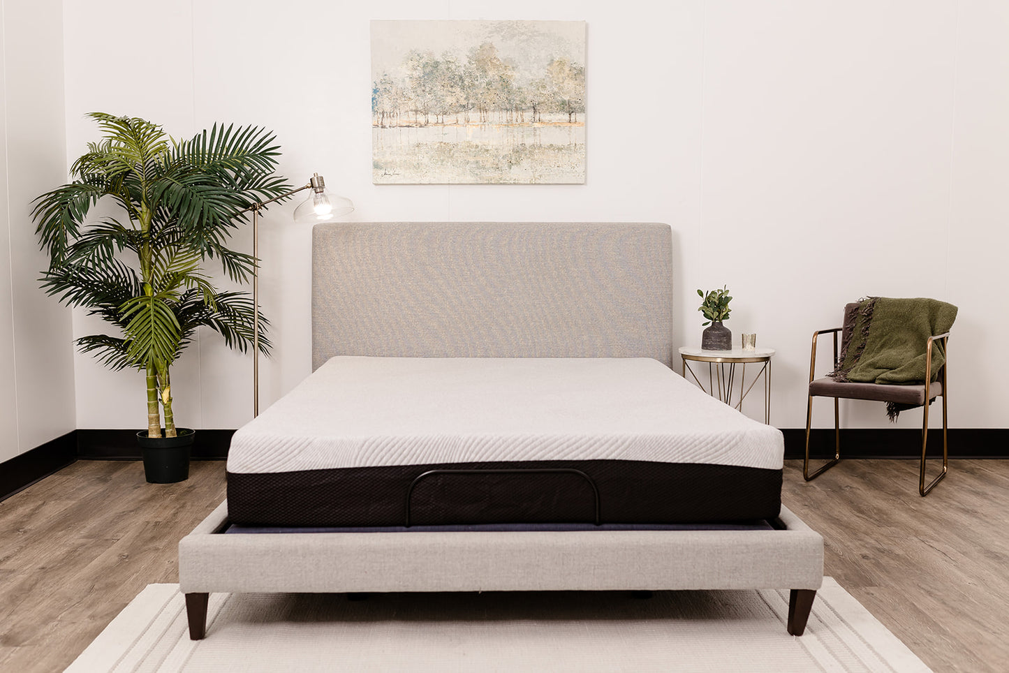 Adjustable bed frame with white mattress and grey upholstered headboard