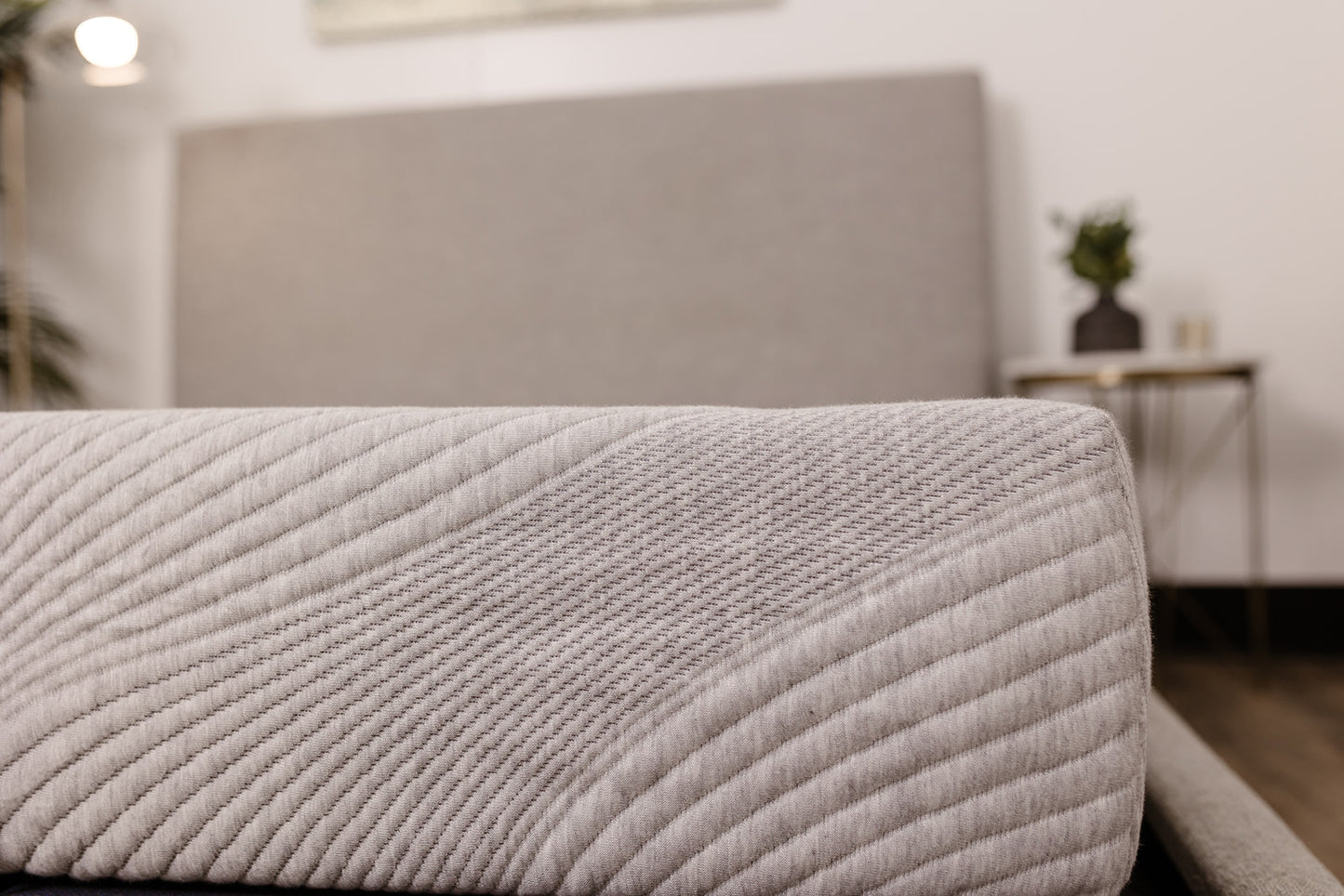 Close up of quilted grey mattress edge with diagonal stitching pattern