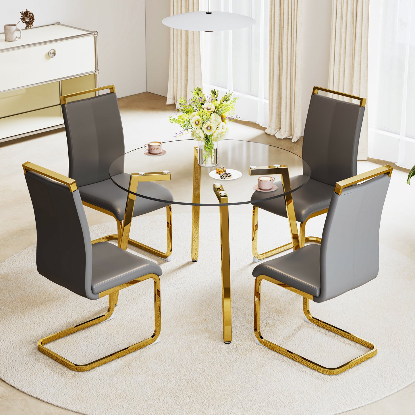 Glass top dining table with gold legs and four grey upholstered chairs