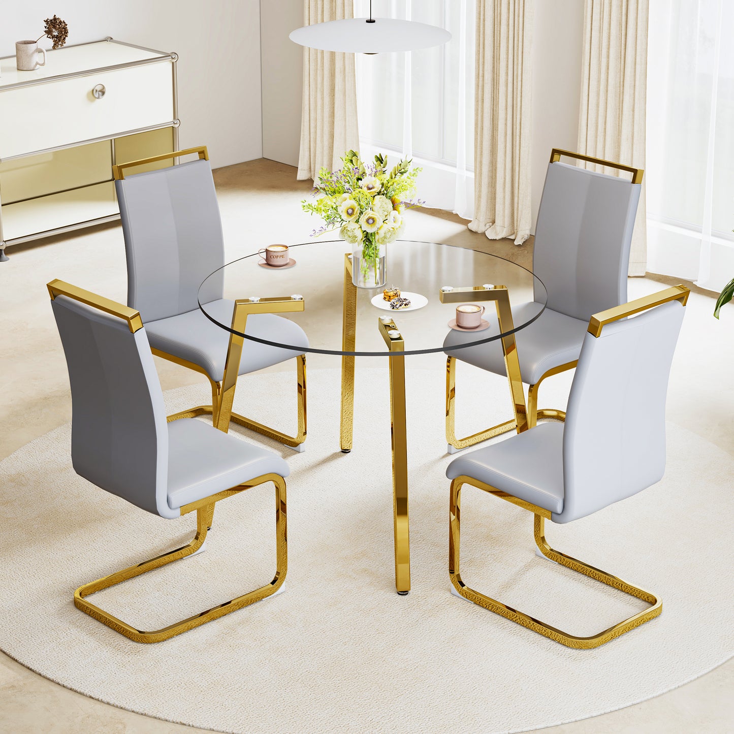 Round glass dining table with gold legs and four grey chairs