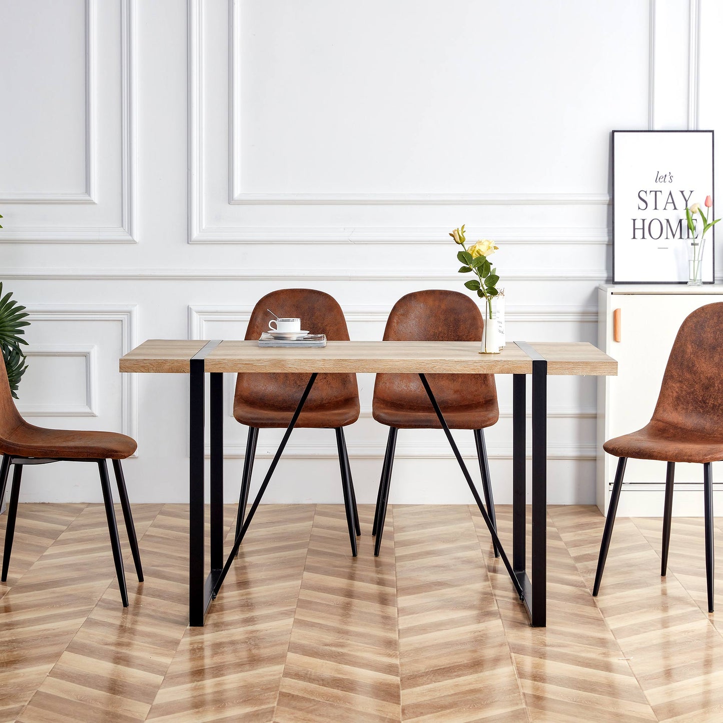 Modern oak dining table with black metal legs and four brown distressed leather chairs