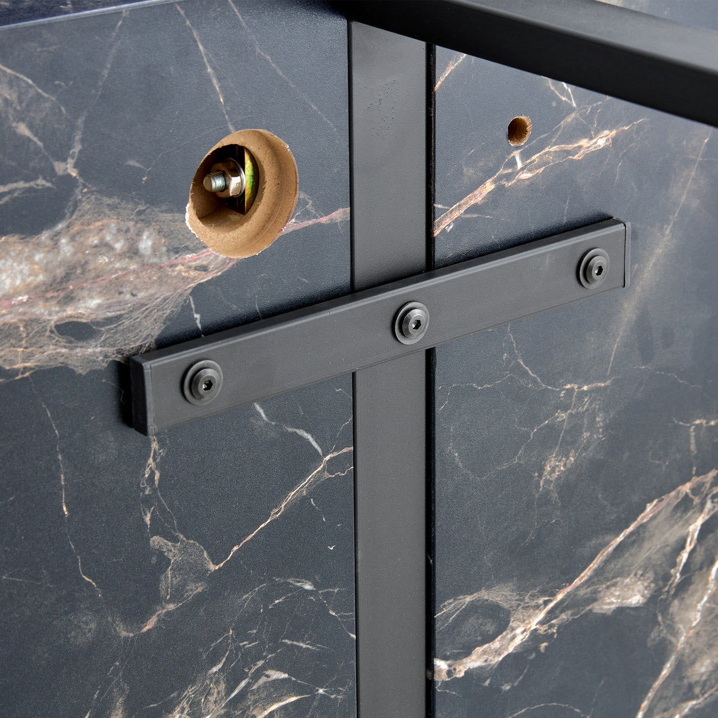 Closeup of black marble effect panel with gold veining and metal frame support