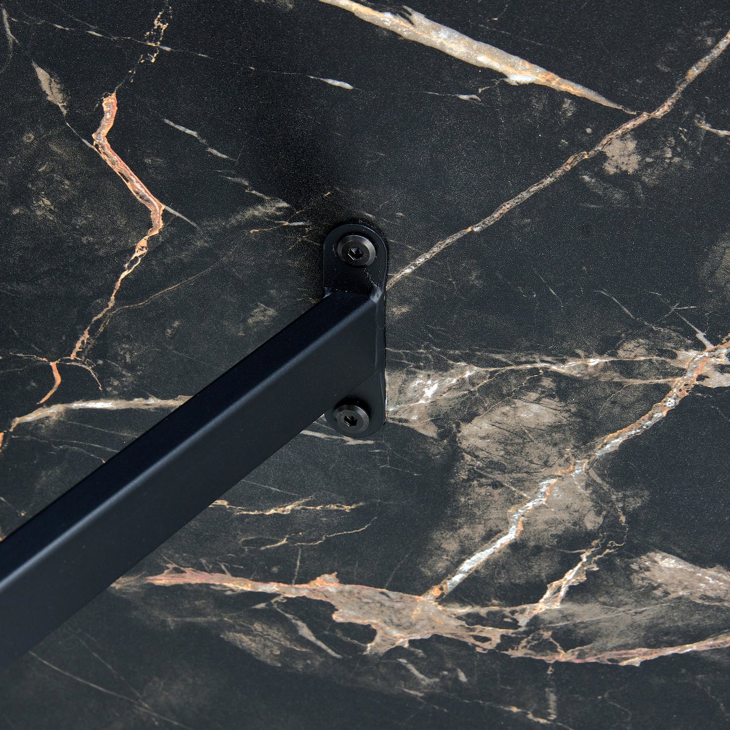 Closeup of black marble countertop with gold veining and a black metal bracket