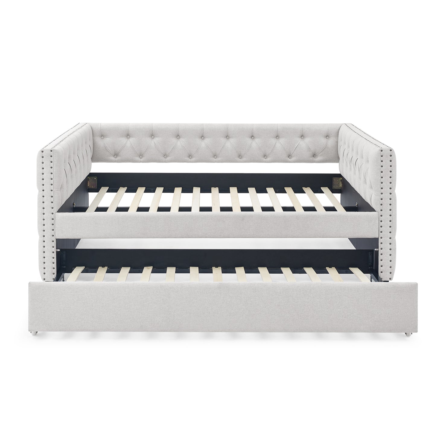 Light gray upholstered daybed with tufted back and nailhead trim featuring a pullout trundle bed for guest sleeping