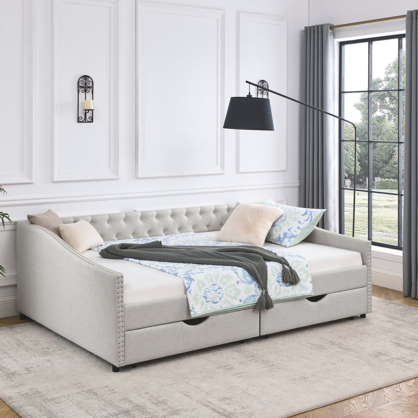 Tufted back light gray fabric daybed with nailhead trim and two storage drawers