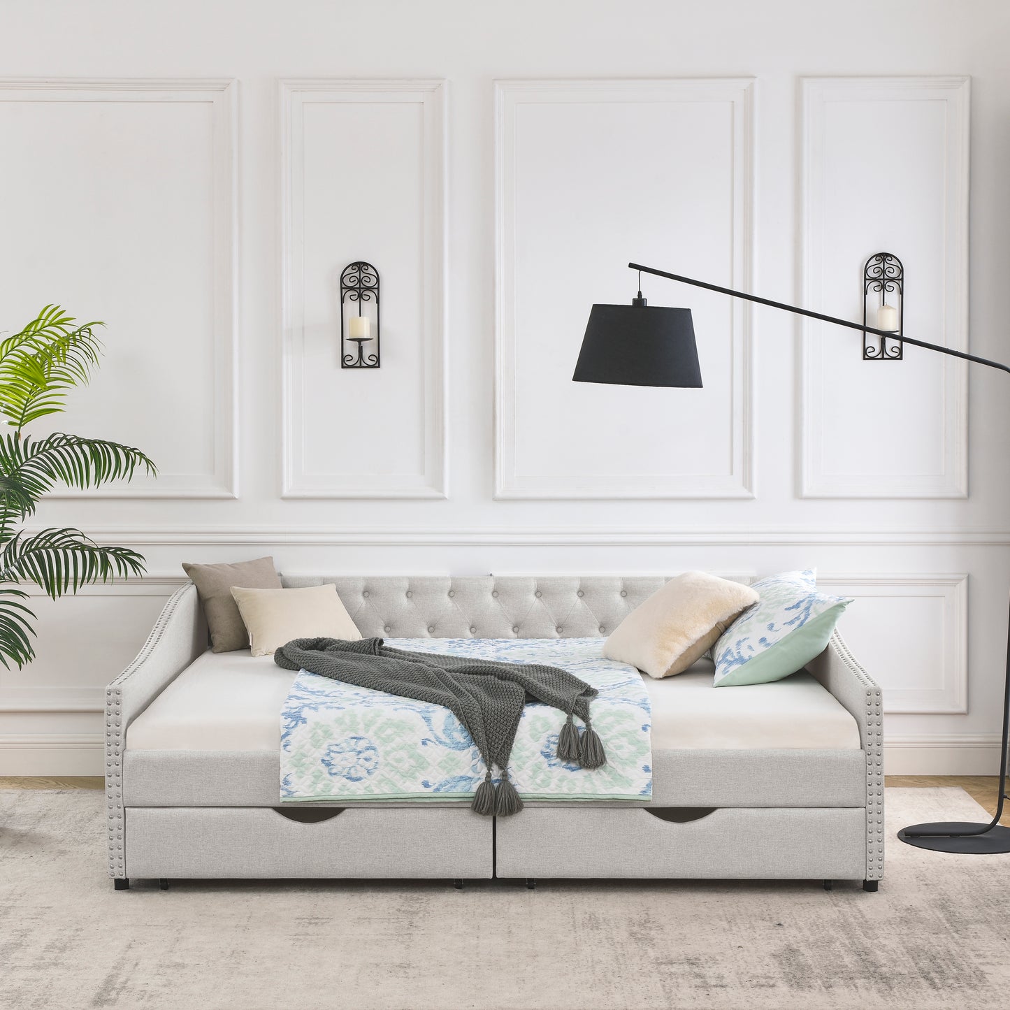 Light gray upholstered daybed with diamond tufting and nailhead trim detail