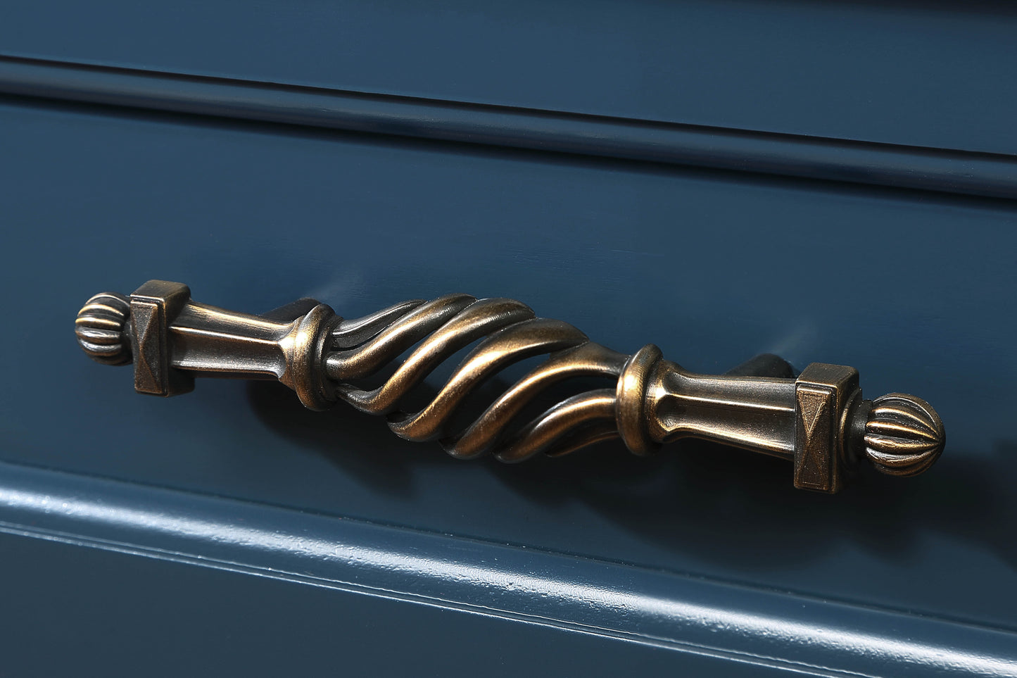 Ornate antique brass drawer pull with twisted spindle design and ribbed finials
