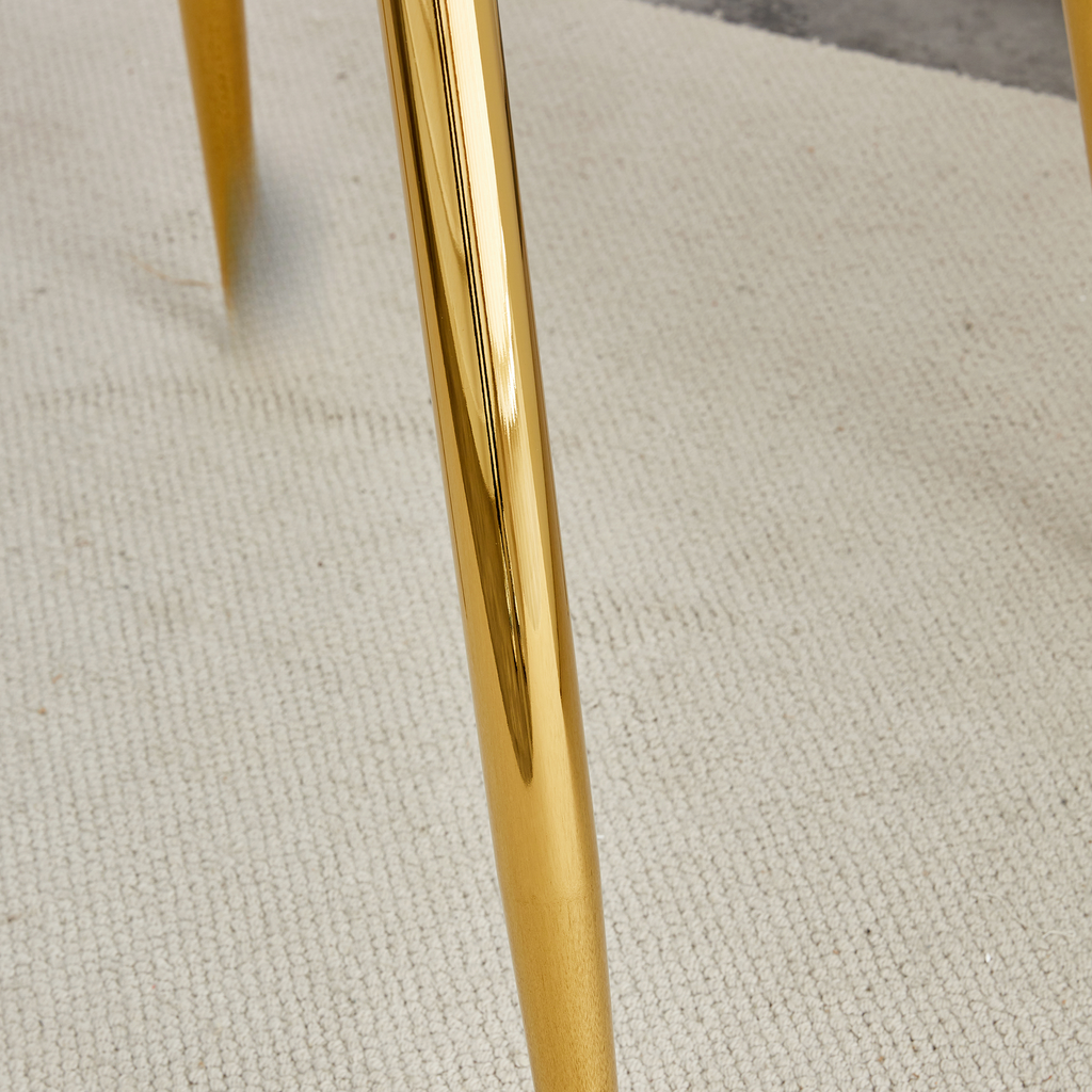 Shiny gold metal table legs on textured rug
