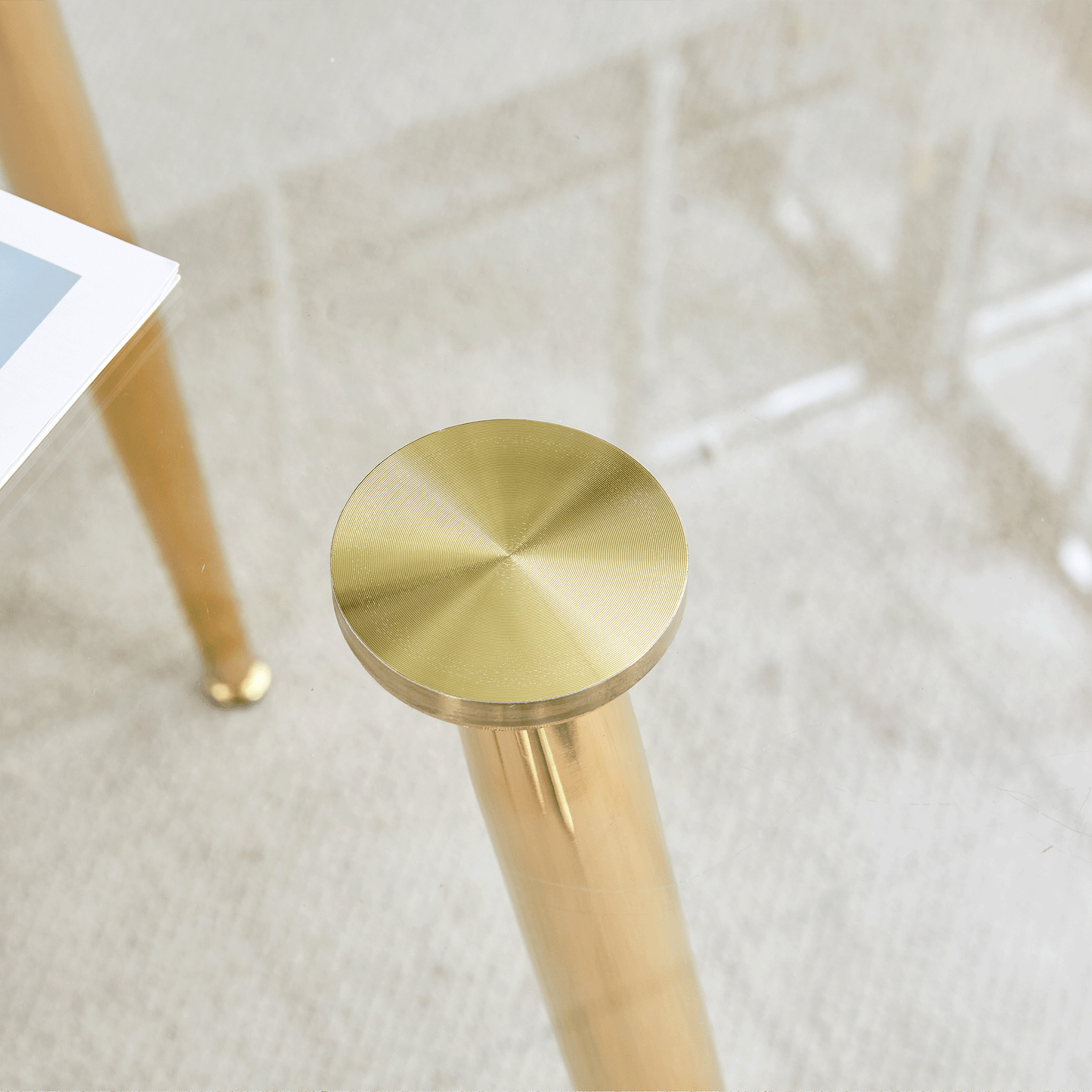 Closeup of a brushed brass table leg with a circular detail
