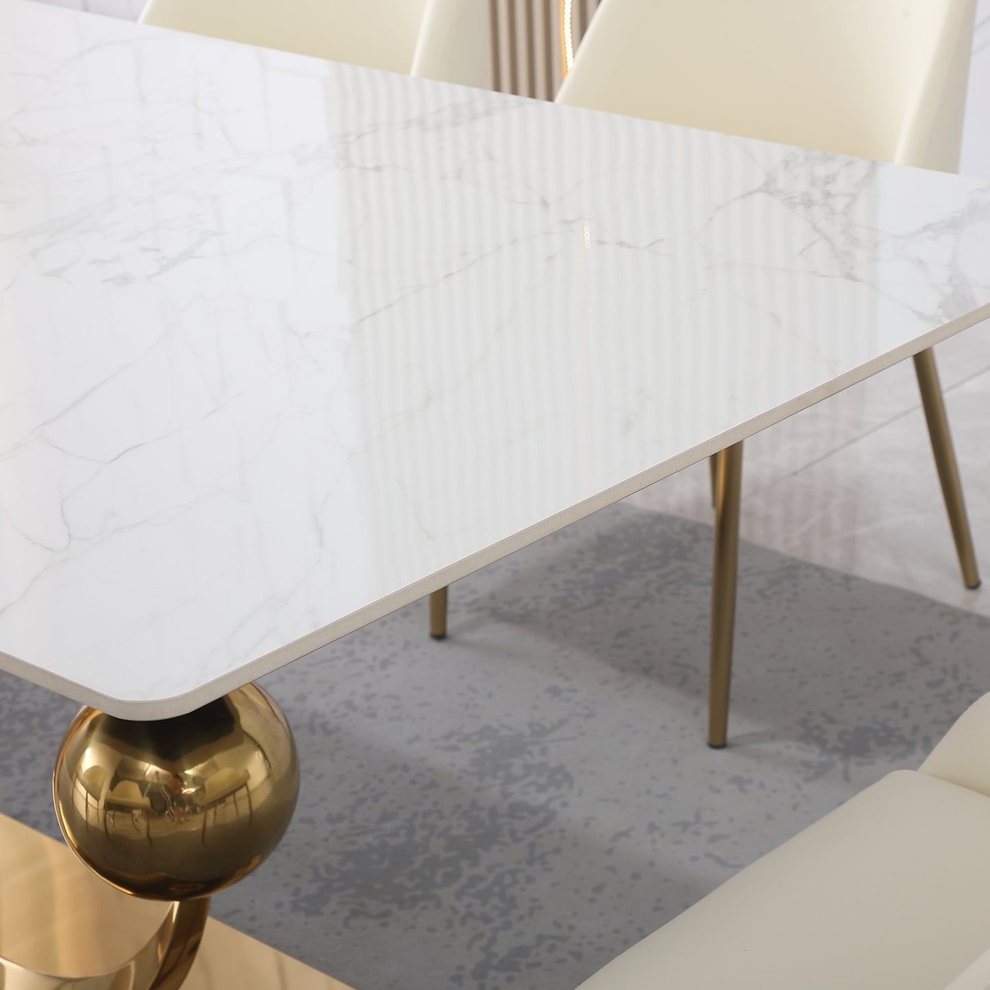 Modern white marble dining table with gold spherical base and metal legs