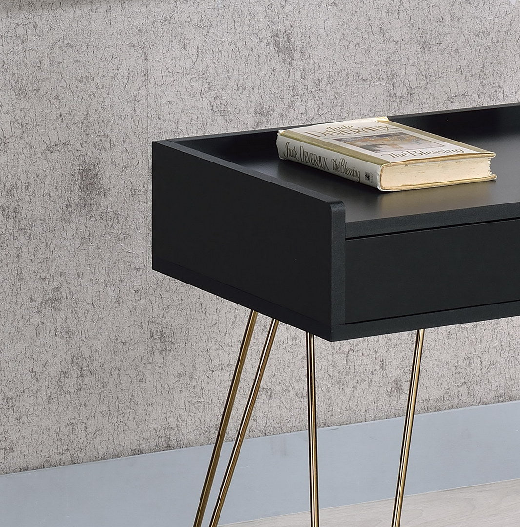 Black bedside table with tapered gold legs and a single drawer