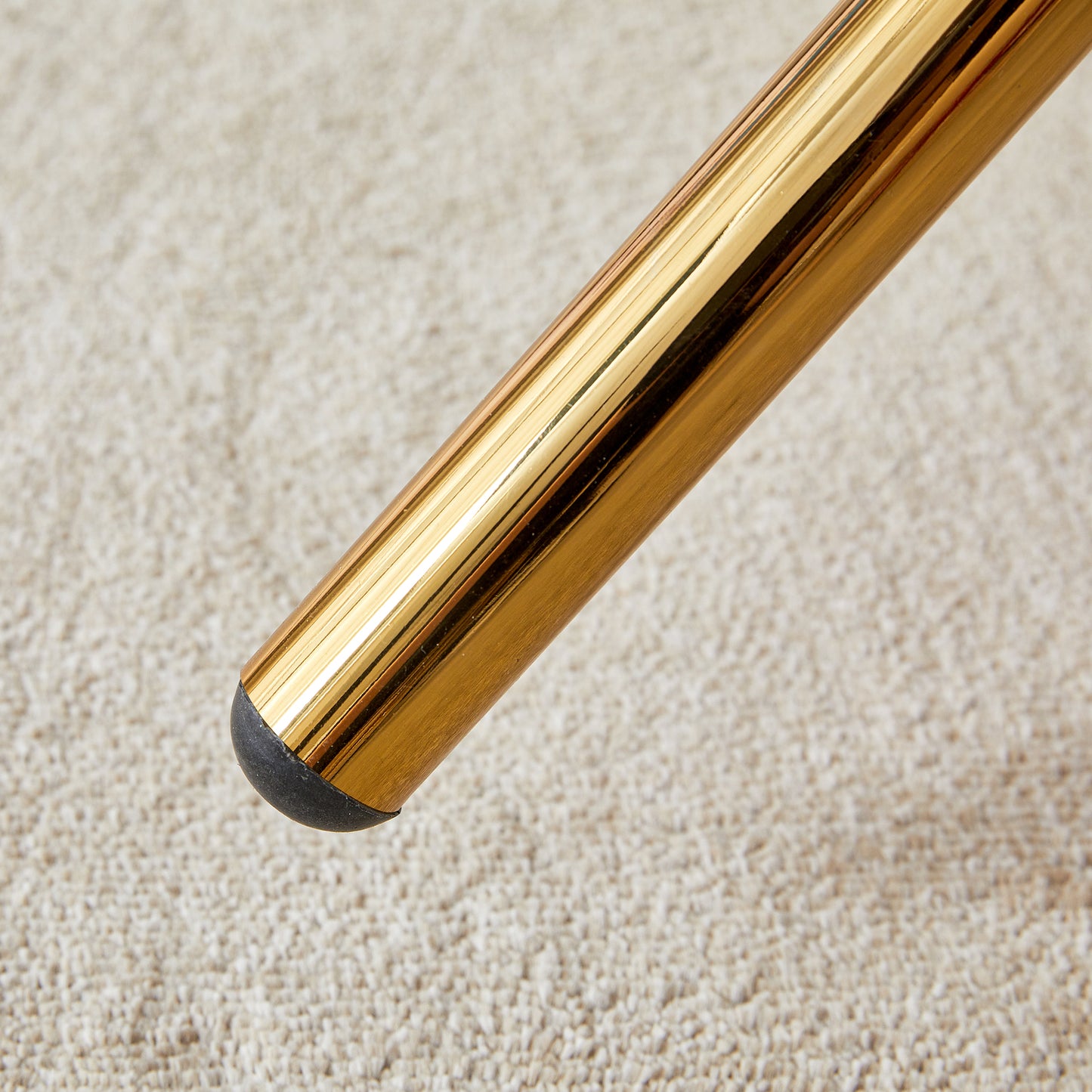 Polished gold metal table leg with black floor protector