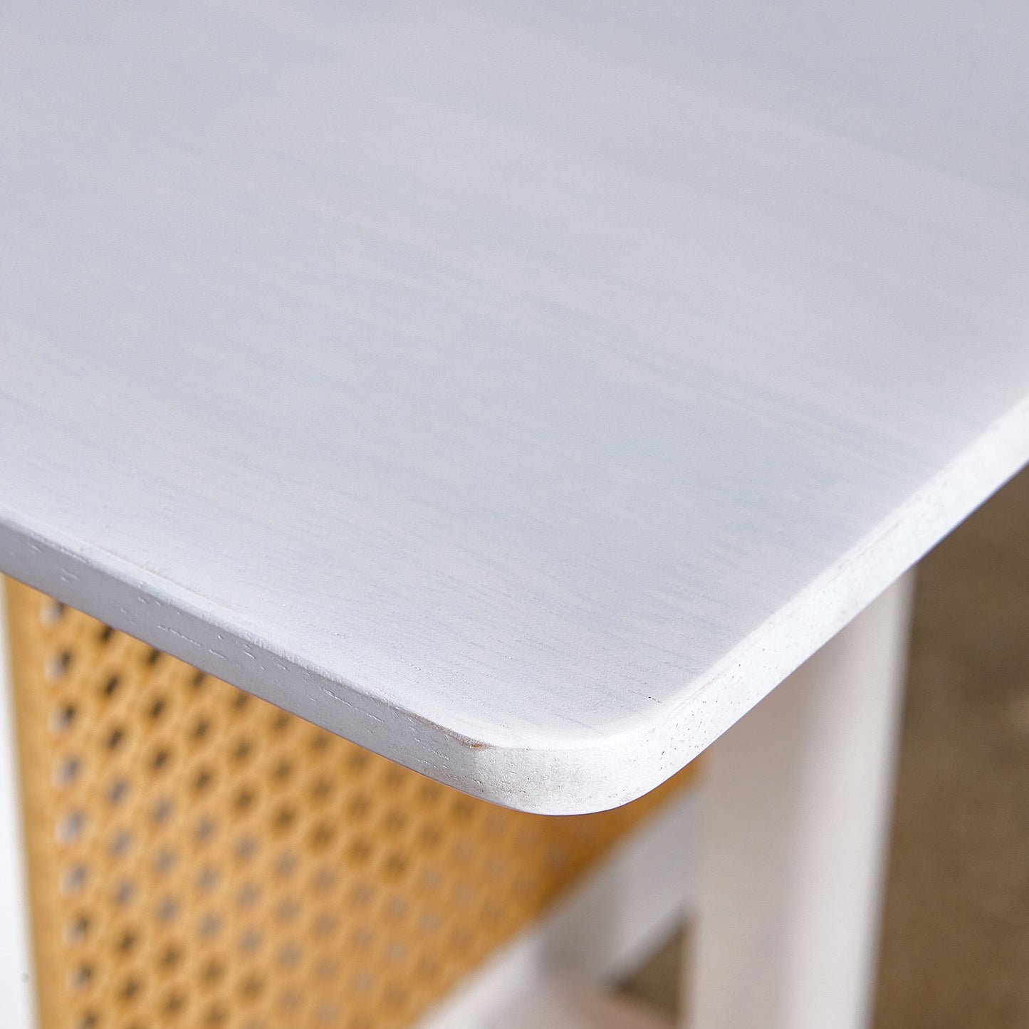 White washed wood table surface with rounded corner and visible grain texture