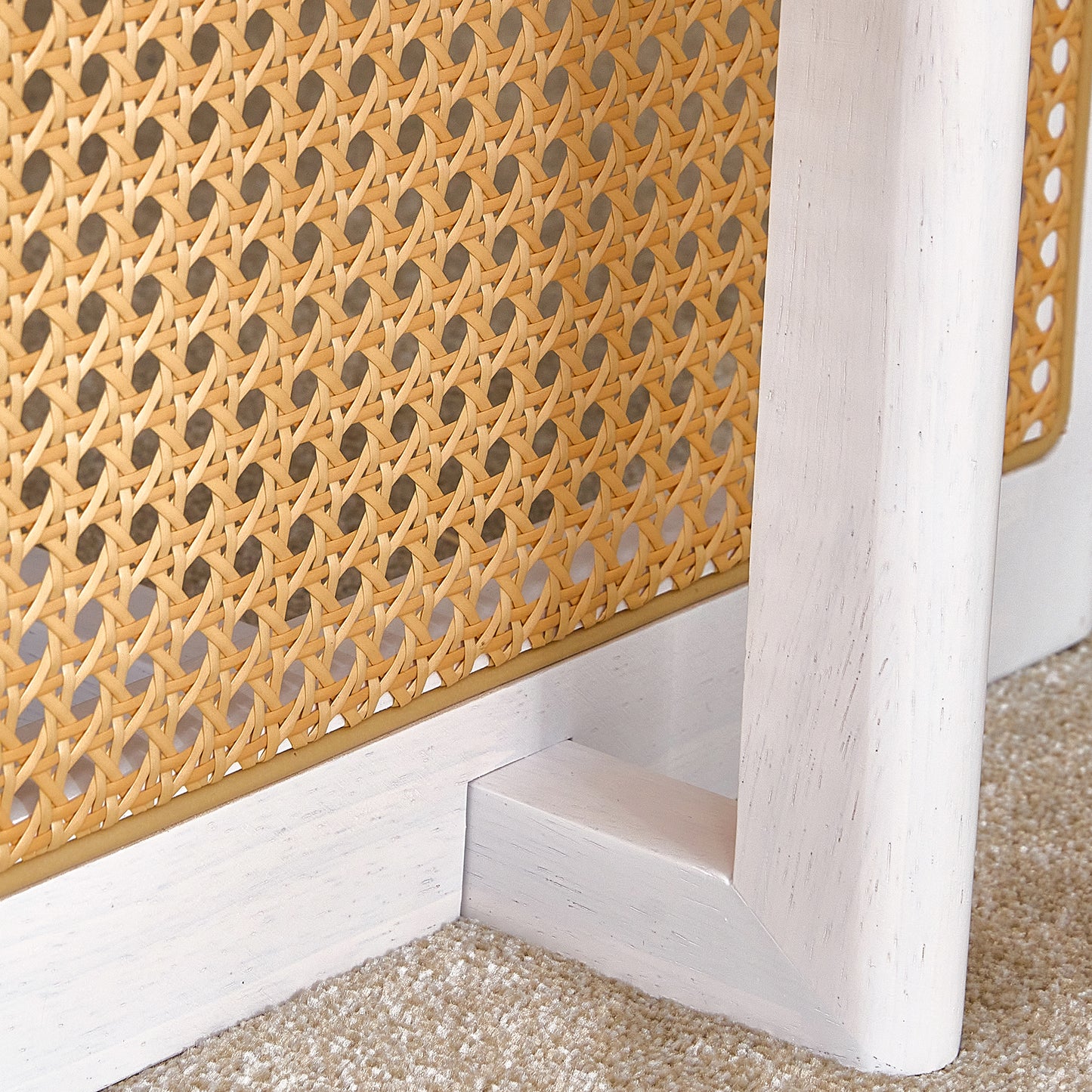 Woven cane cabinet panel detail with distressed white wood frame