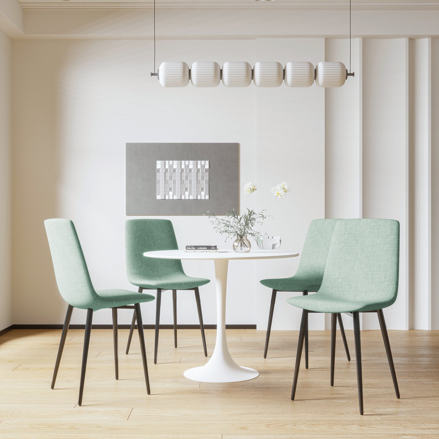 Four light green upholstered dining chairs with black legs around a white tulip table