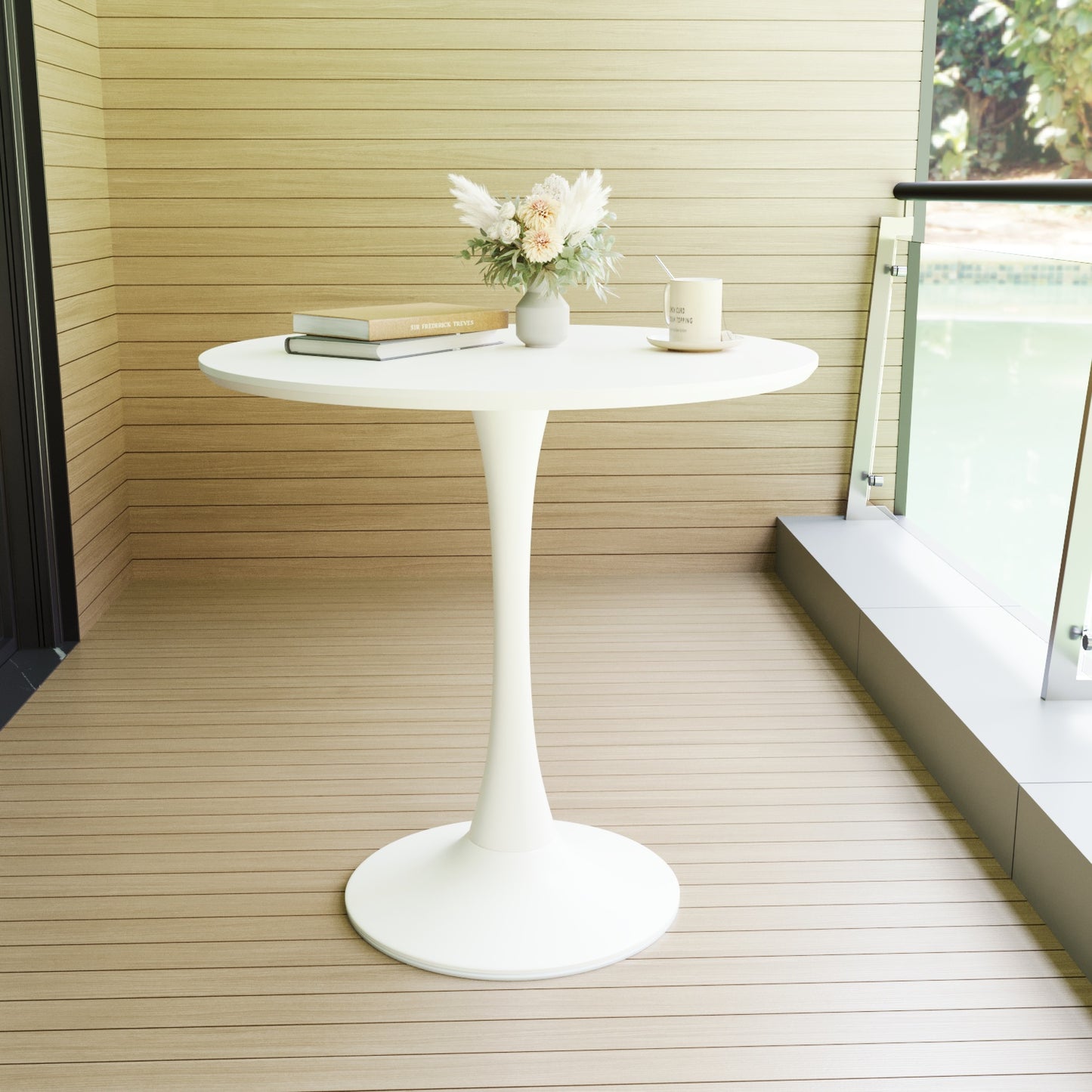 White tulip bistro table with stacked books and floral arrangement