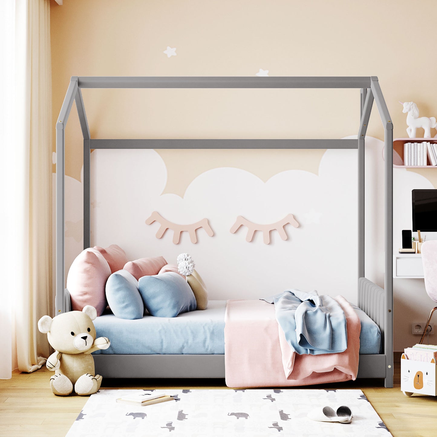 Grey wooden house bed frame with pastel bedding and stuffed animals