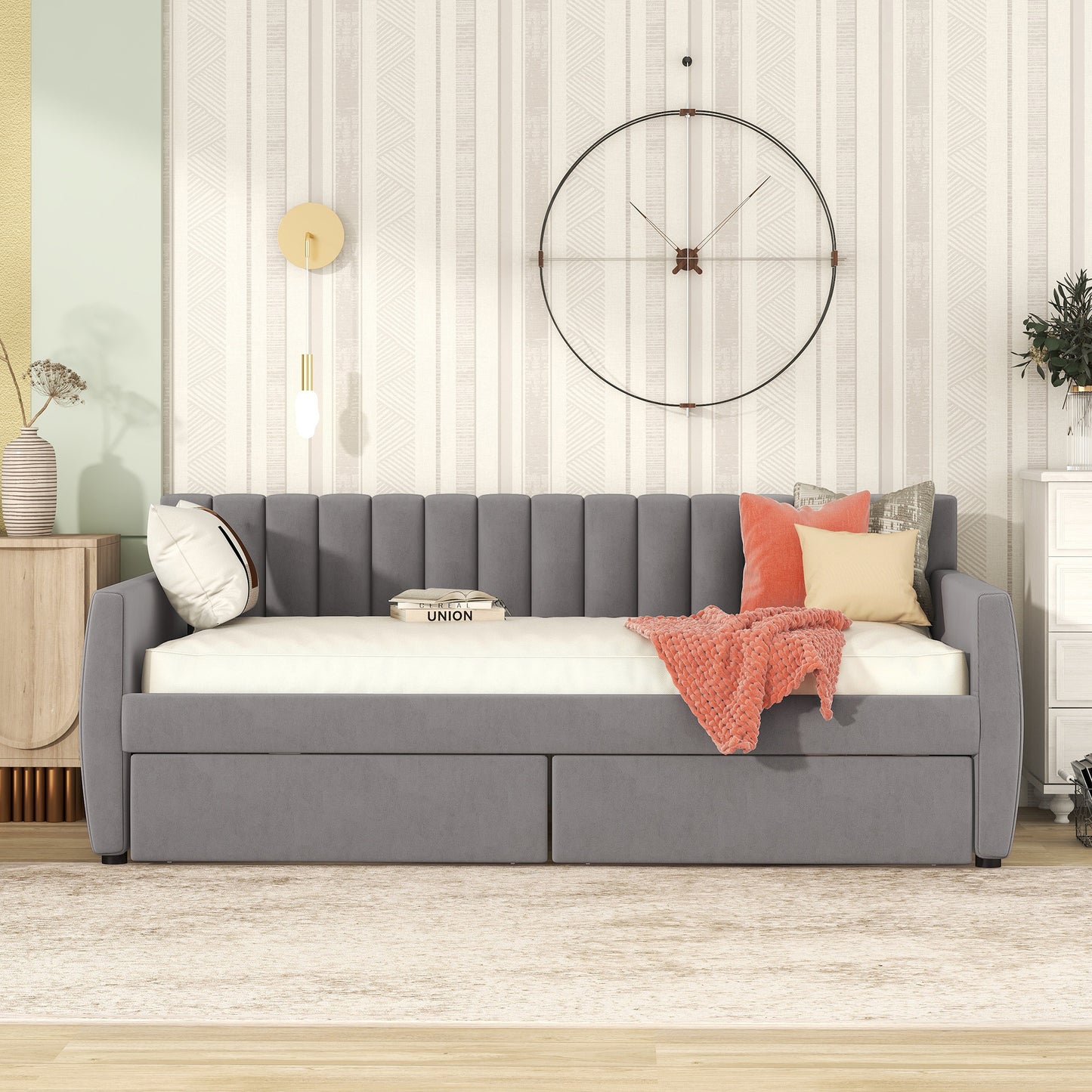 Grey velvet daybed with tufted back and storage drawers styled with coral pillows