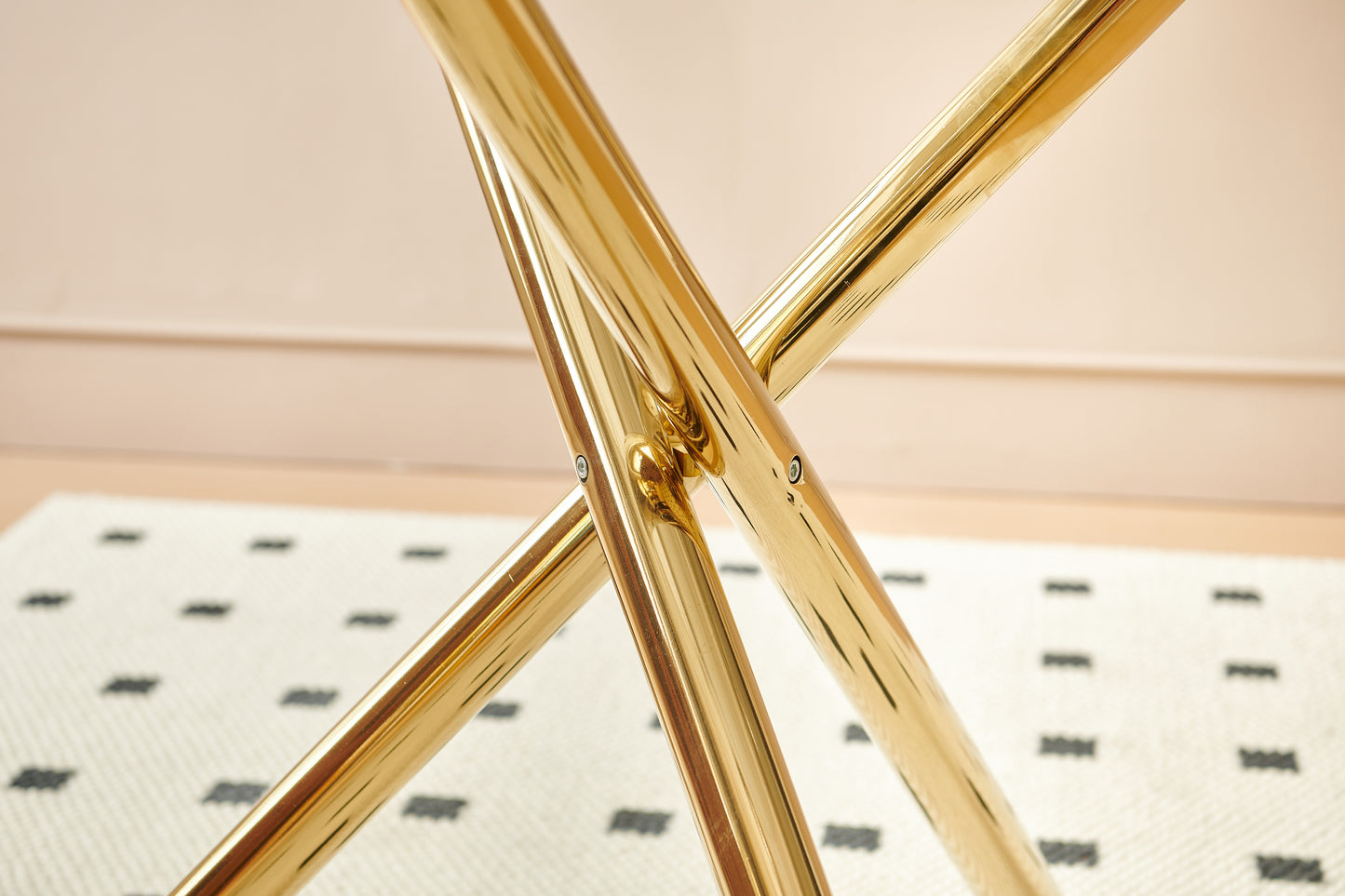 Polished brass table legs with a crossbraced design