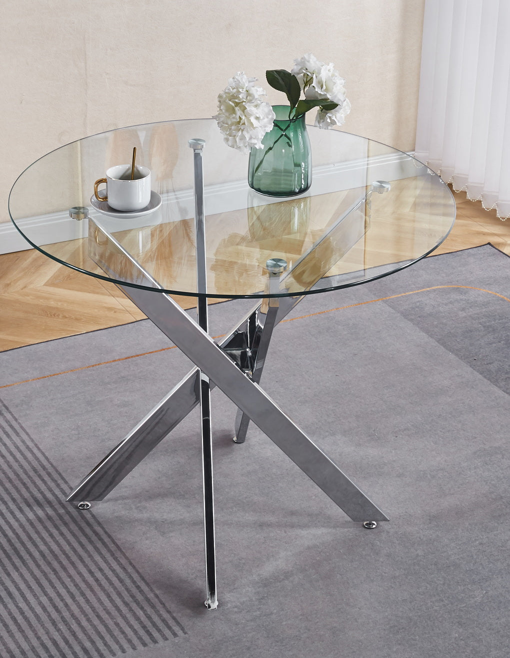 Round glass coffee table with chrome crossleg base