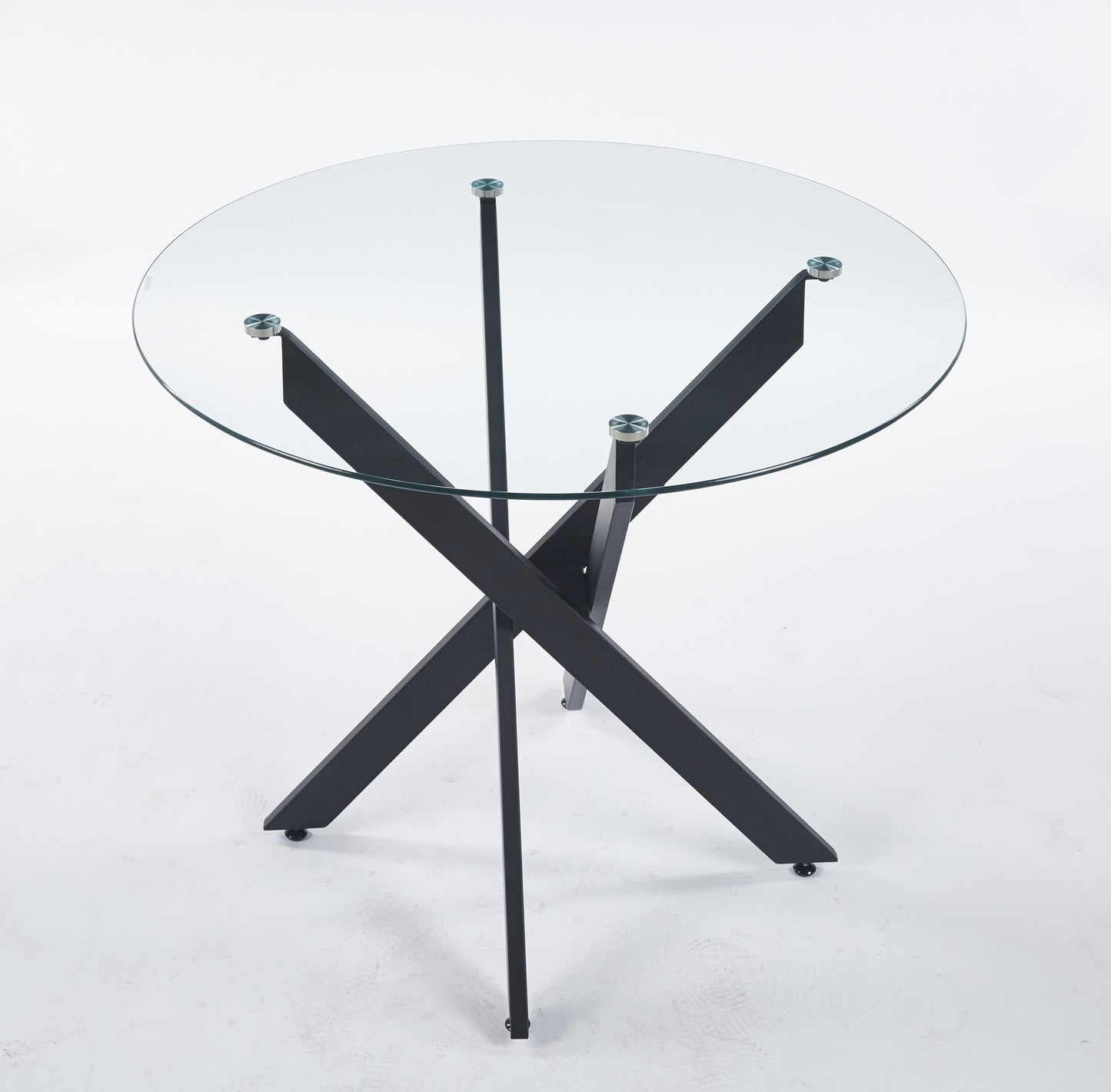 Round glass coffee table with black Xshaped metal legs and clear tabletop