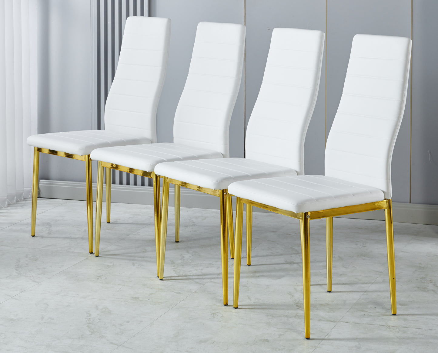 Four white upholstered dining chairs with gold legs