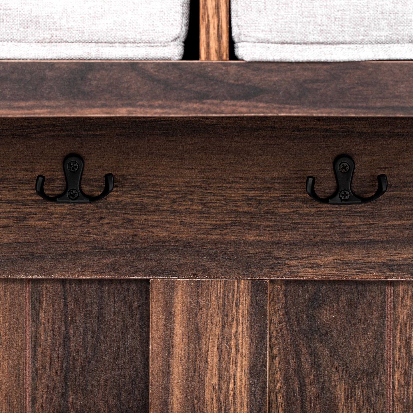 Closeup of dark wood shelf with two black metal coat hooks