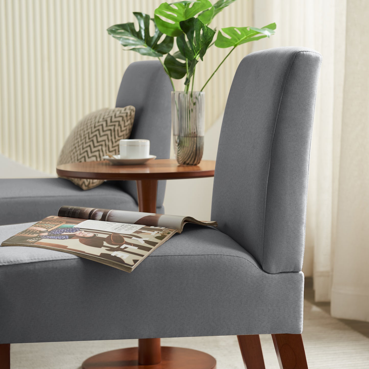 Grey upholstered accent chair with magazine